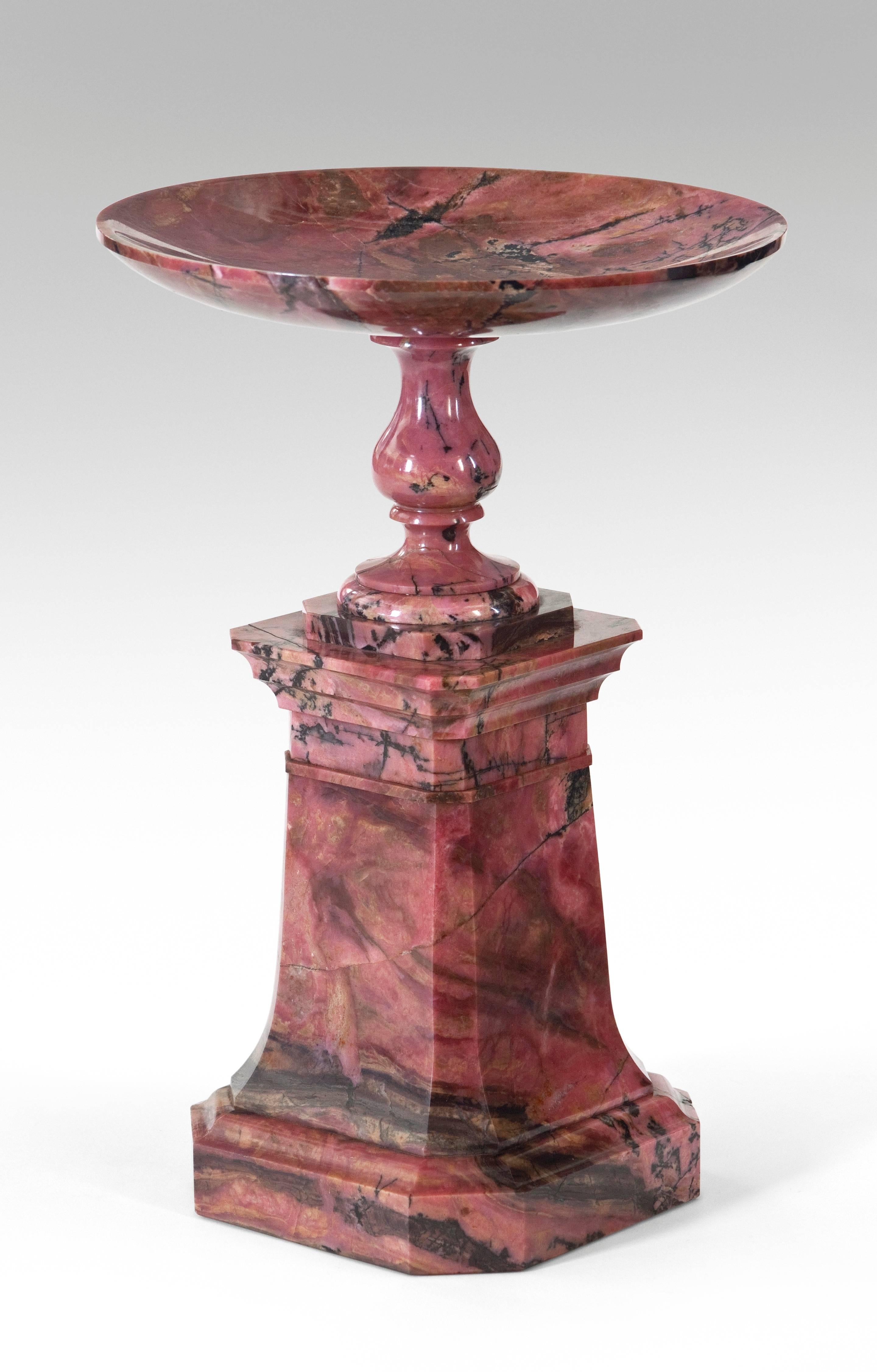 Exceptionally high quality craftsmanship and choice selection of beautifully deep colored, radiant pink rhodonite. The shallow circular dish above the baluster socle, raised on a canted square spreading pedestal and conforming molded base.

Very