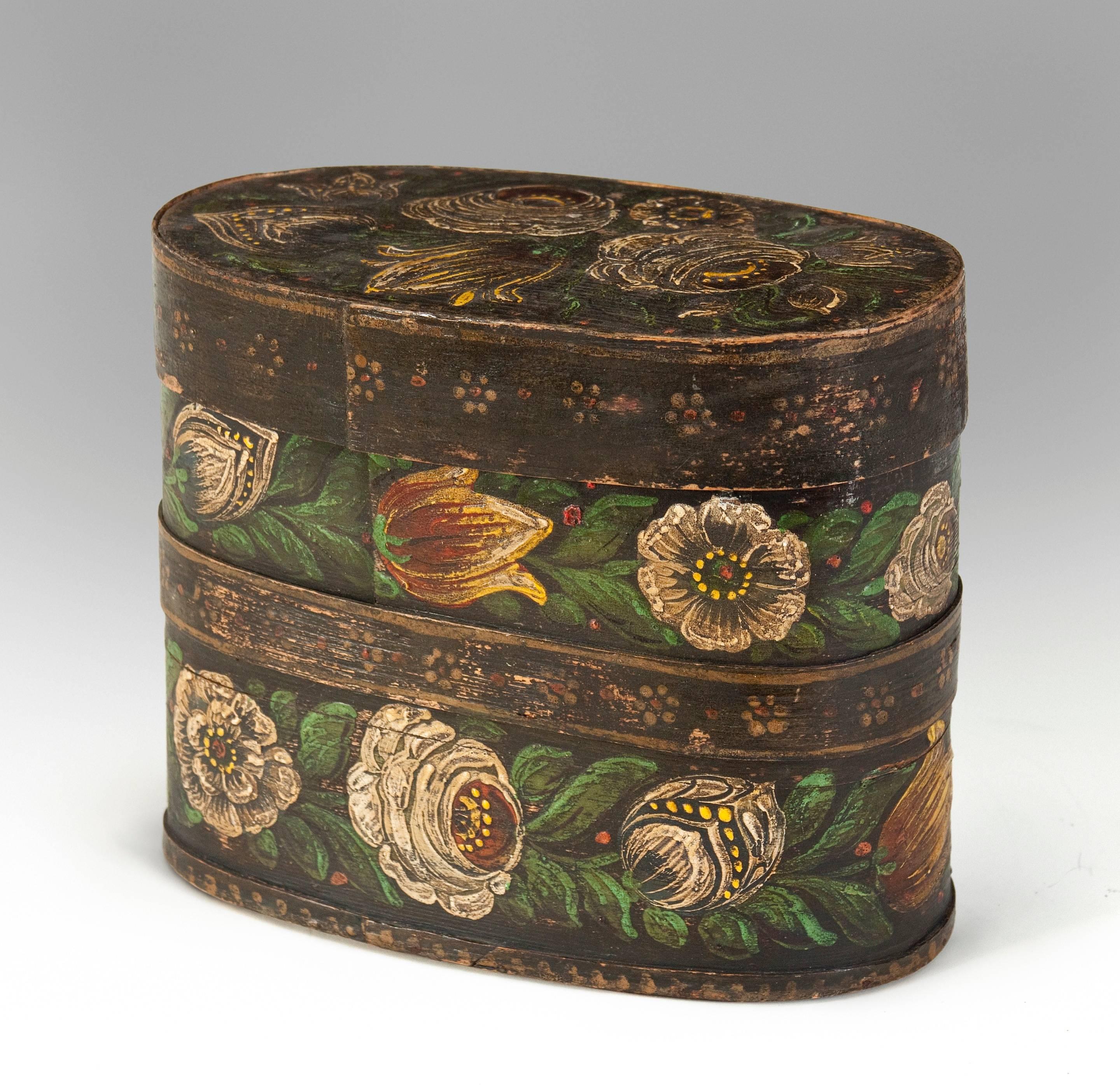 A beautiful example of an early painted box adorned with lovely flowers. The oval lid with a floral bouquet and a rim of a frieze of daisies, the base decorated with garlands of tulips, roses and peonies separated by a band of daisies.