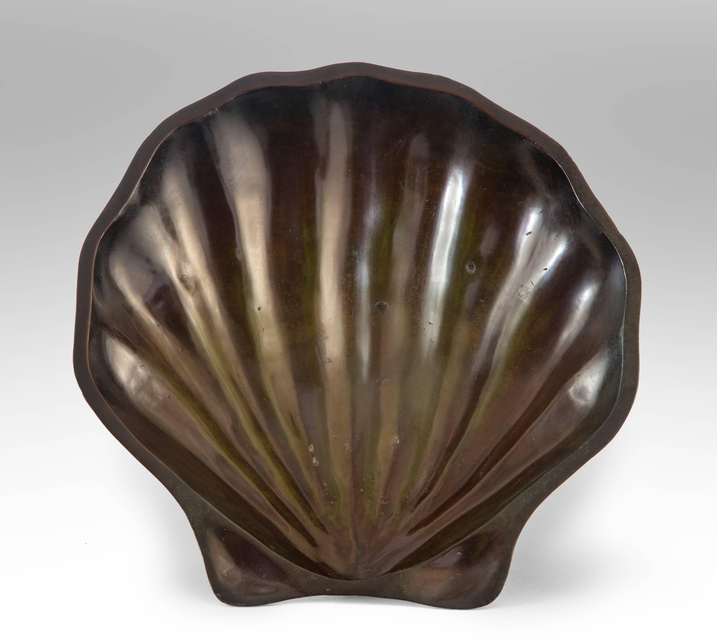An extraordinary and substantially cast of a rarely seen shell center piece. Of scallop form raised on three nautilus shell feet.