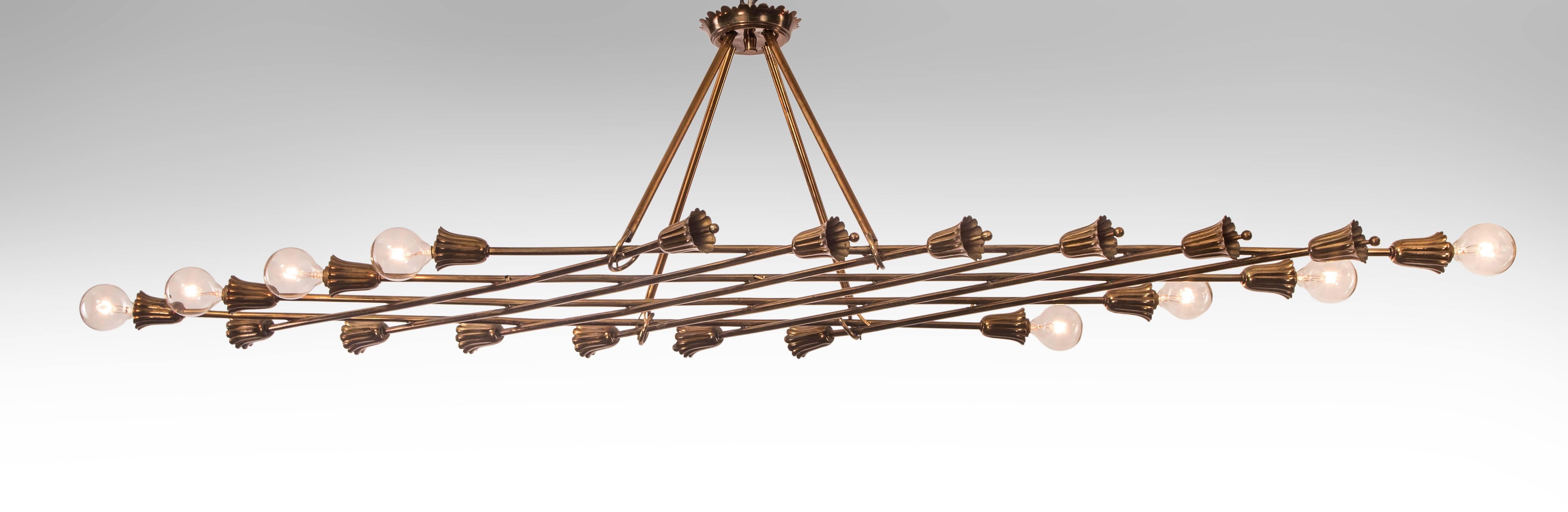The crown shaped canopy, above four hanging rods suspending a latticework of brass tubes, terminating in blossoms with stamens and eight flower-shaped light holders.