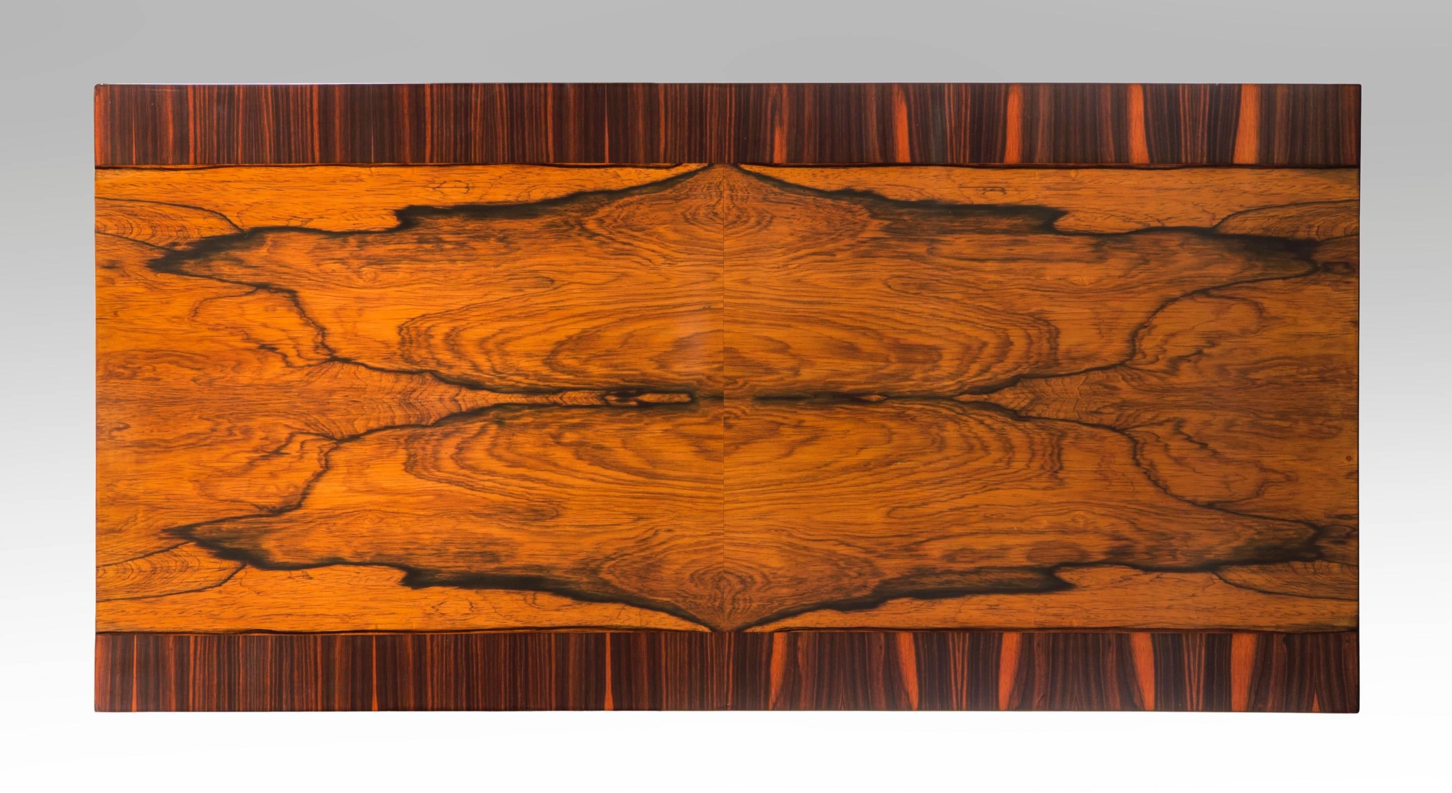 Wonderful robustly contrasting veneers enliven this table. The rectangular bookmatched palisander top crossbanded with macassar ebony, raised on ebonized fluted columnar legs headed by foliate capitals. Stamped: R within a triangle (for Reiners