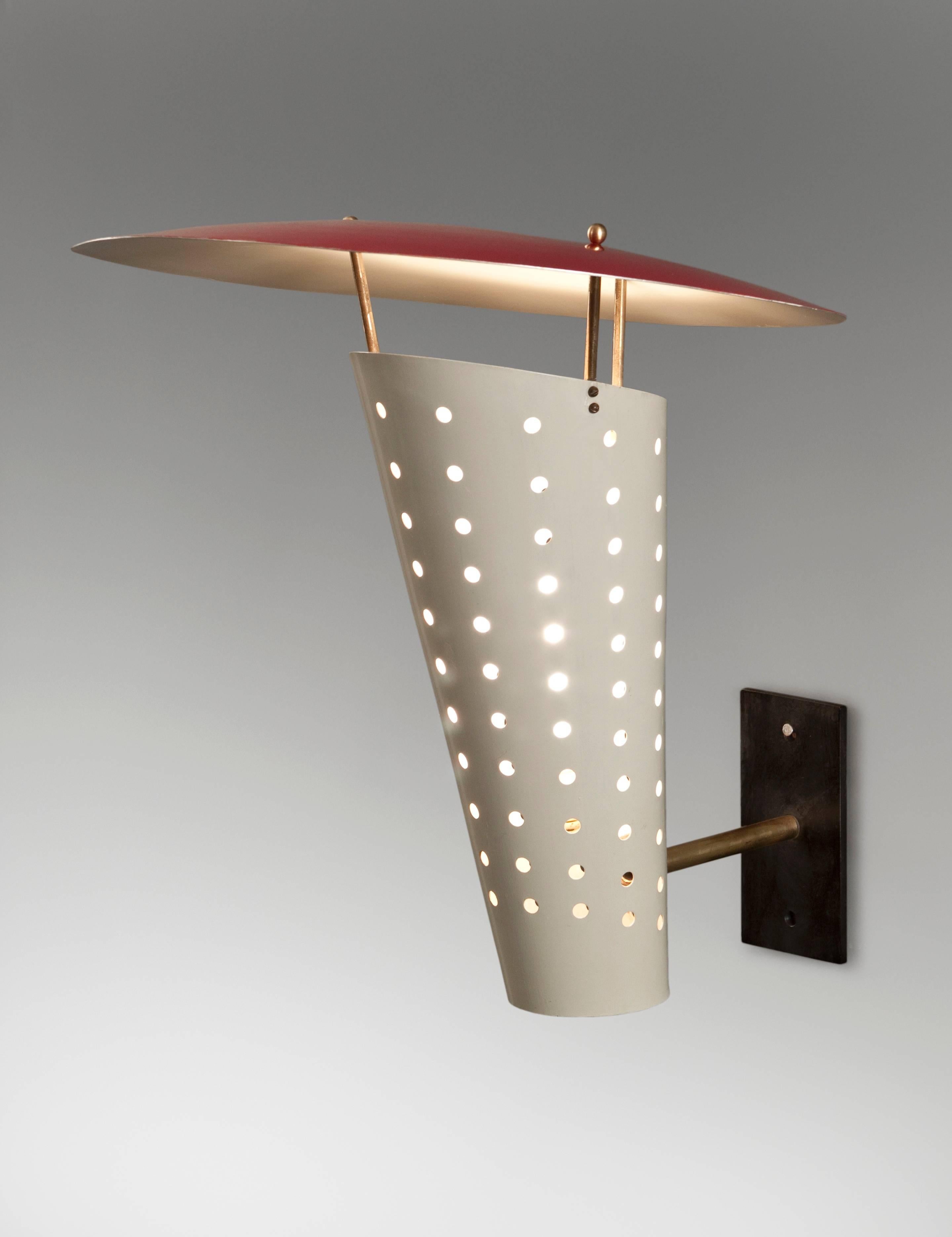 Large scale modernist sconces of a sophisticated yet deceptively simple design. The circular domed reflector raised on three uprights, above a perforated conical diffuser, supported by a rectangular backplate. Original paint in very good