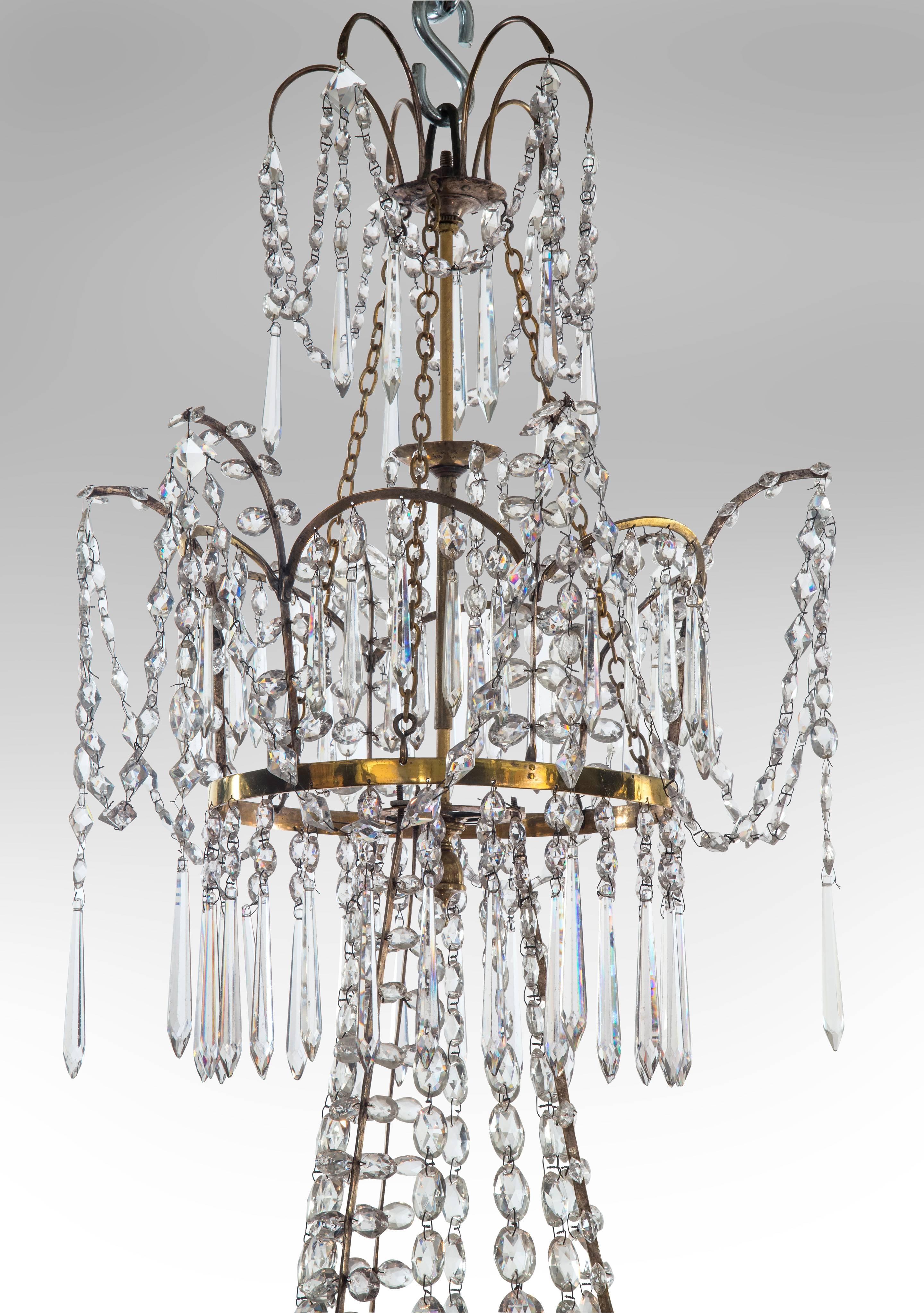An exceptional chandelier of elegant proportions. The two tiered corona fitted with arches hung with swags and faceted drops, the central cascade of graduated strands and feather sprays, the principal tier fitted with six S-shape arms supporting urn