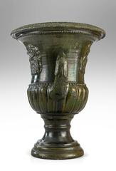 A French Green Glazed Faience Campana Urn with Elephant Relief