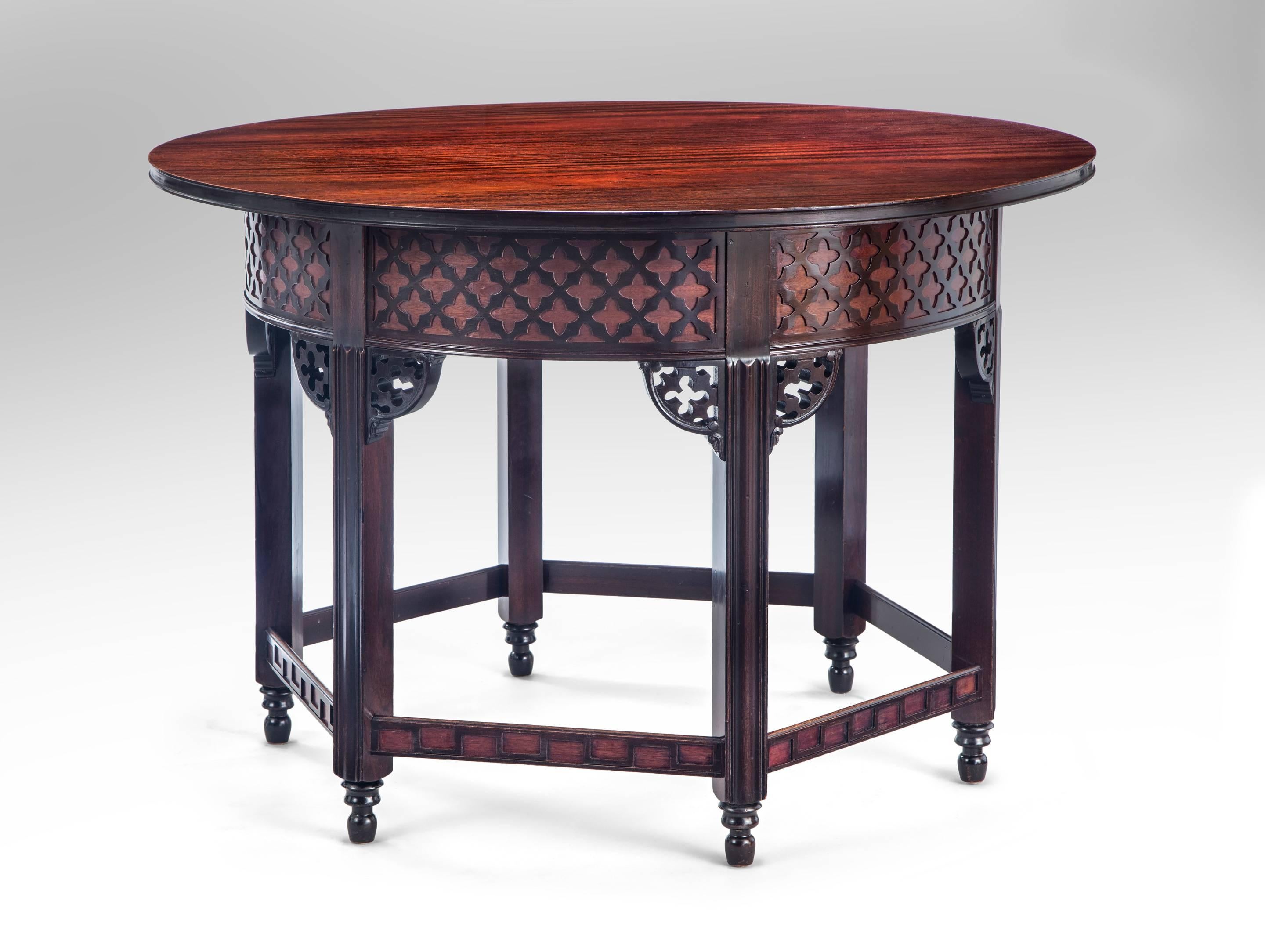 The circular mahogany top, above a quatrefoil latticework frieze, the six molded legs headed by pierced brackets and connected by a latticework stretcher, raised on turned feet. 
Marked on the reverse of top: Hantverks och