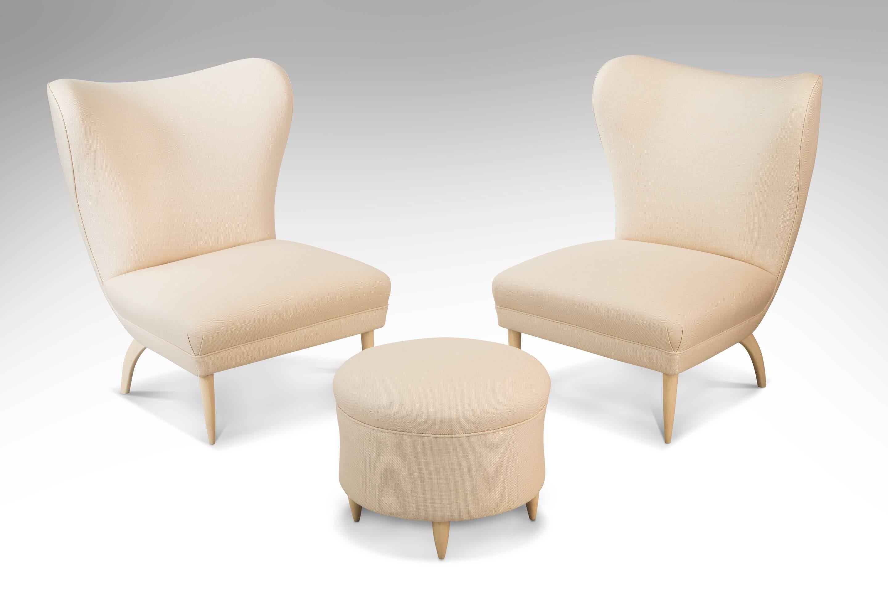 A comfortable and understated chair with beautiful lines and highly distinctive legs. The winged back toprail, above a concave backrest, the plush and generous rectangular seat cushion raised on tapering glazed wood legs. 

A related chair is