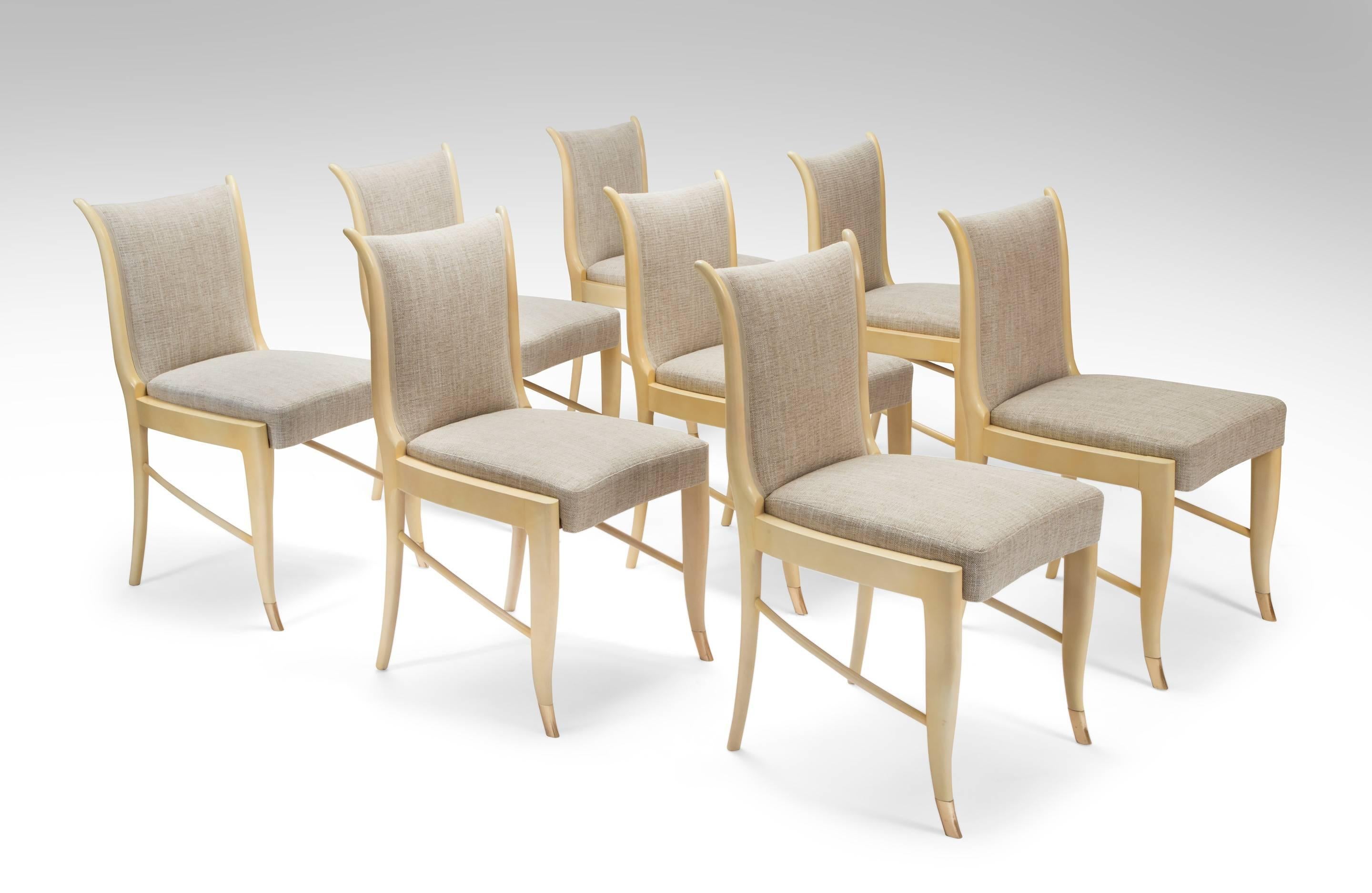 The upholstered backs flanked by curved supports, above a rectangular seat with a concave front, on legs joined by an stylish angled stretcher, terminating in brass front feet.

Available with a parchment dining table marked with Milanese tax stamps