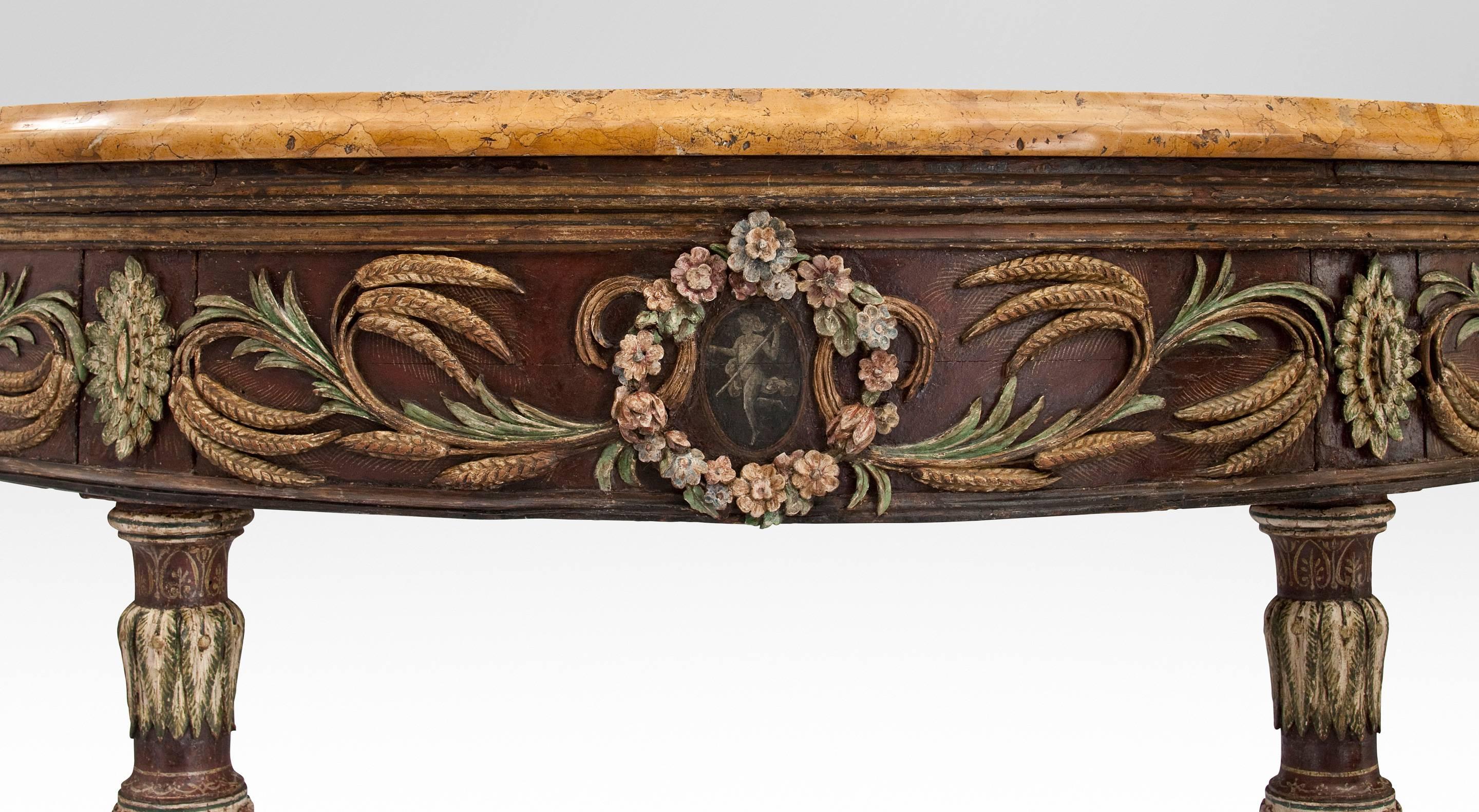 The molded marble-top above the polychromatic apron frieze centered by three circular floral medallions each with a grisaille allegorical reserve, flanked by scrolling blades of wheat and oval paterae, on foliate carved circular tapering fluted legs