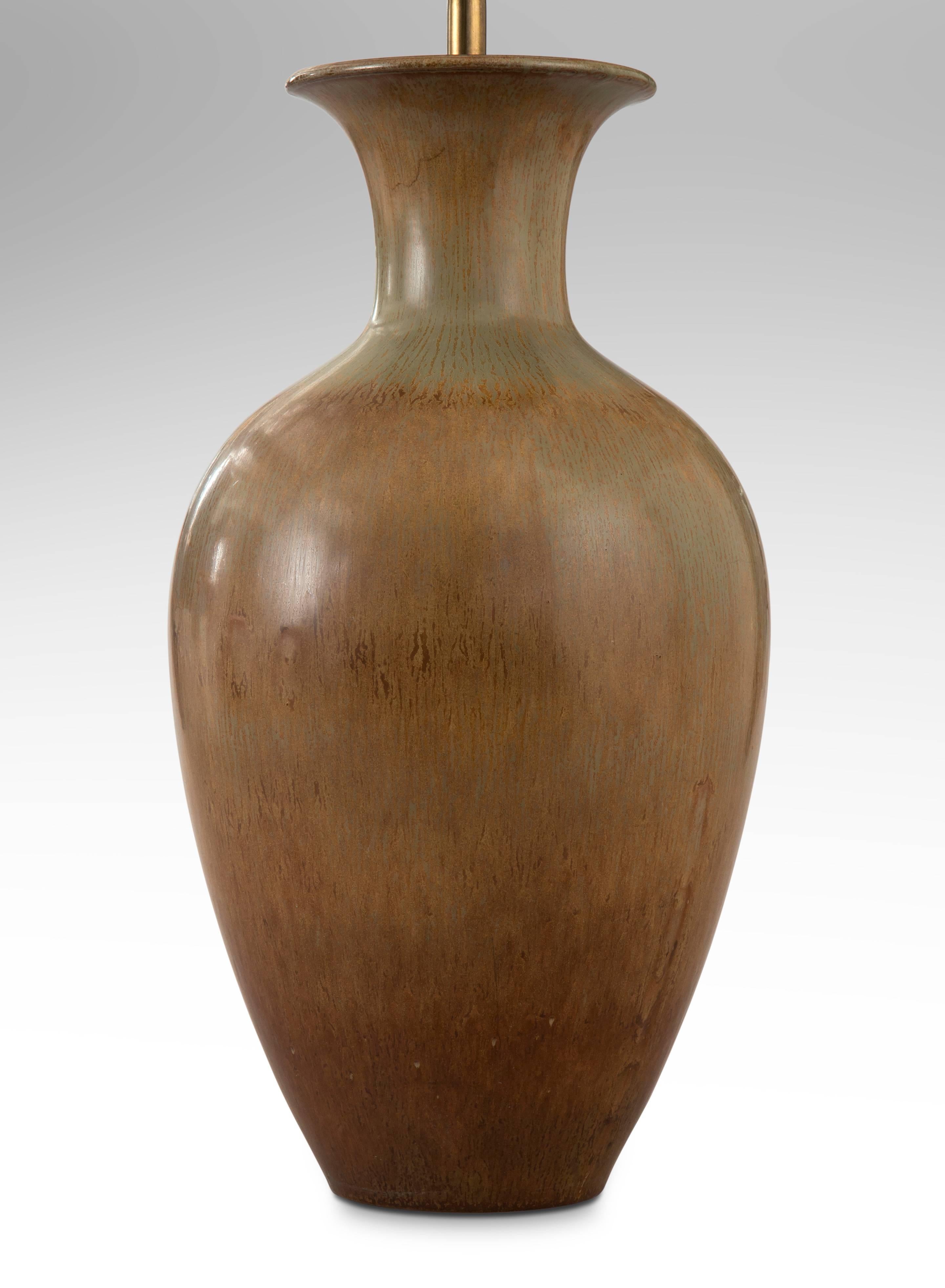 The flared neck above an elegant, high shouldered ovoid body, with a soft green and subtly variegated brown glaze.

Very good condition and ready to add to your collection. Museum wired, not drilled, can easily be converted back into a vase. 