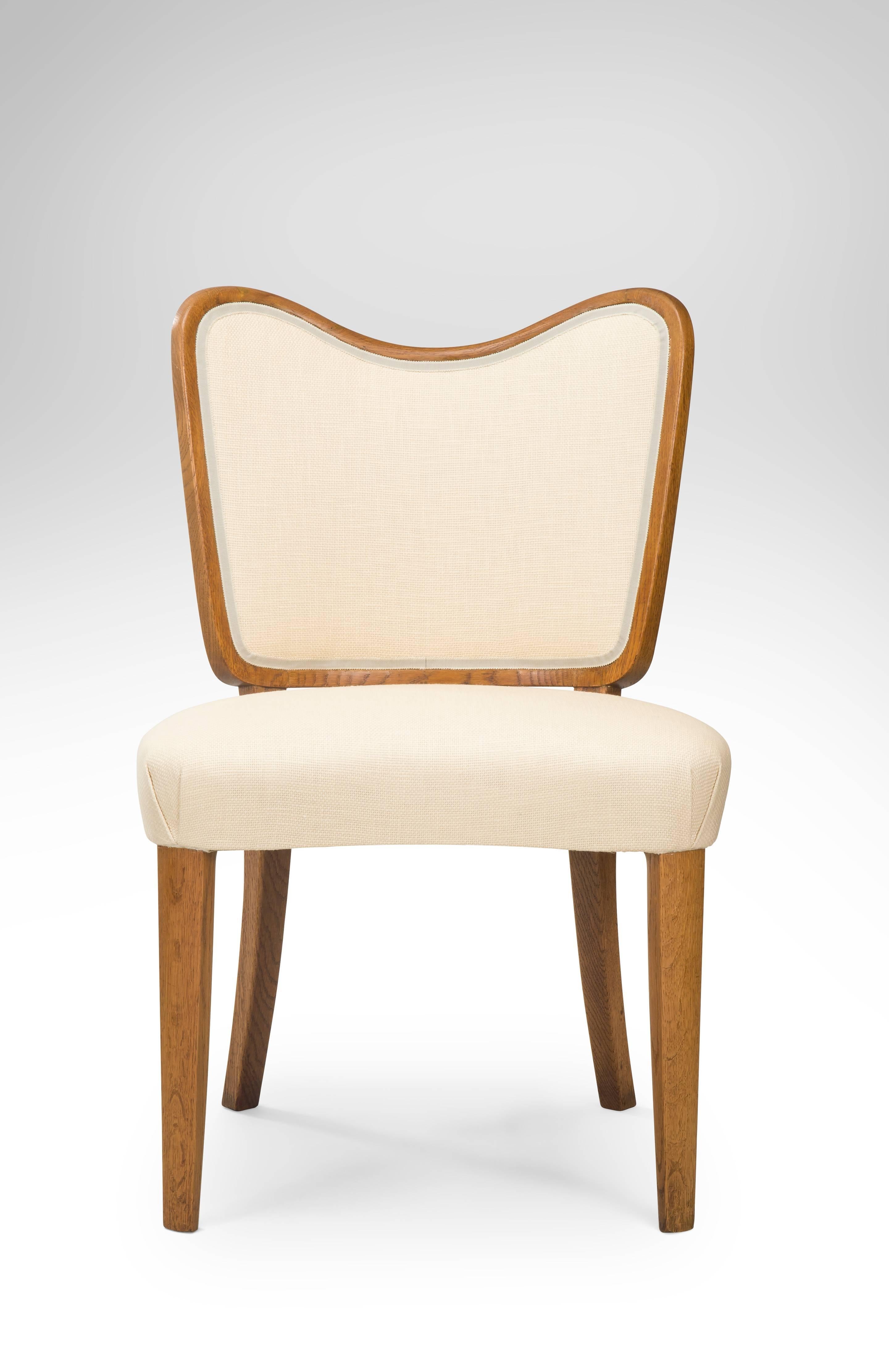 Rare examples in a lustrous golden oak of the renowned designer's later work where he briefly had his own firm. Stylish and very comfortable. Each with a curvaceous backrest above an similarly shaped and upholstered seat, on tapering legs. Stamped: