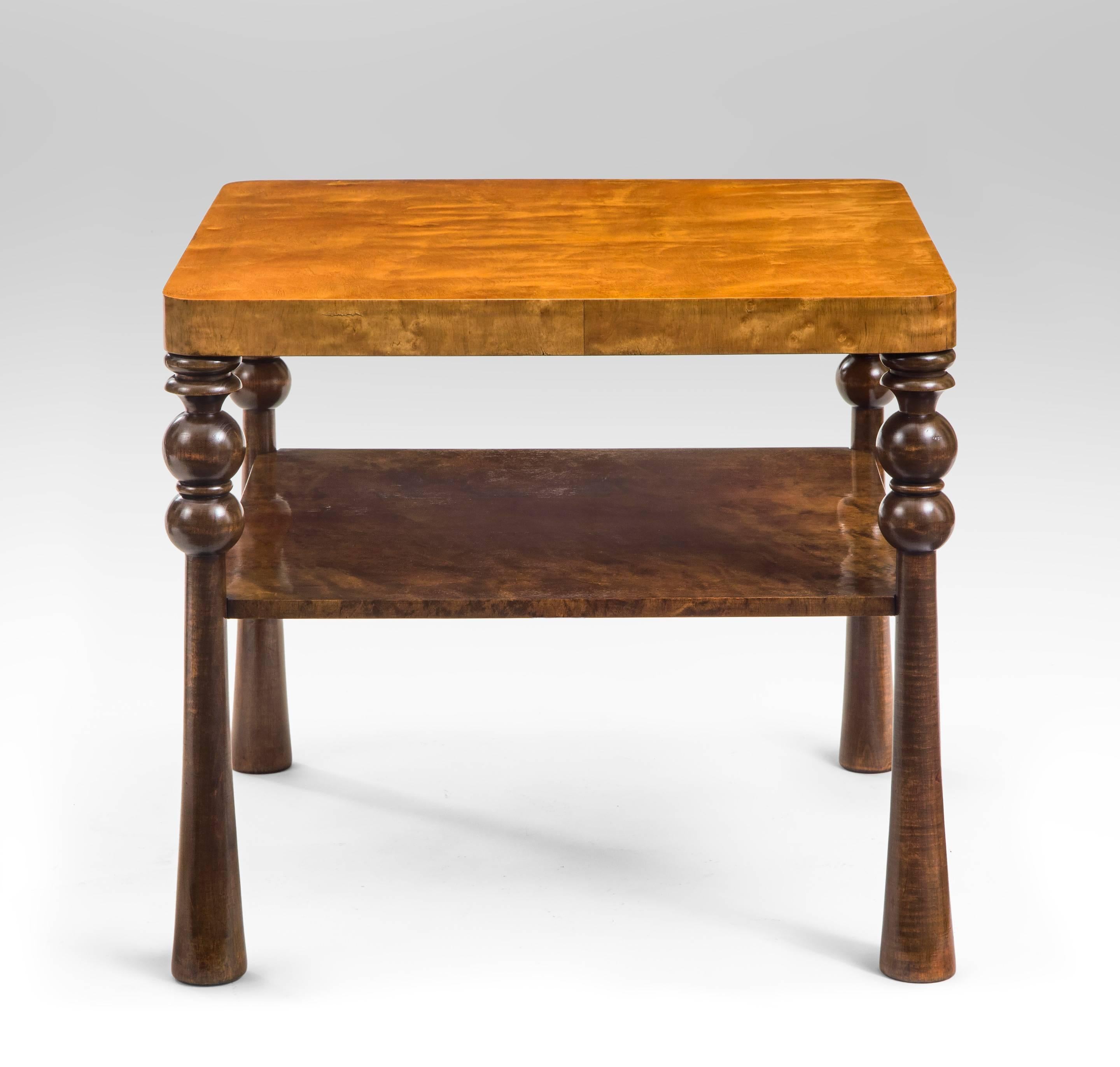 A very crisply designed table of beautiful figured birch. The square top with rounded corners, raised on four turned legs, joined by a lower shelf. 

Professionally restored, Beautifully repolished, ready to add to your collection.
