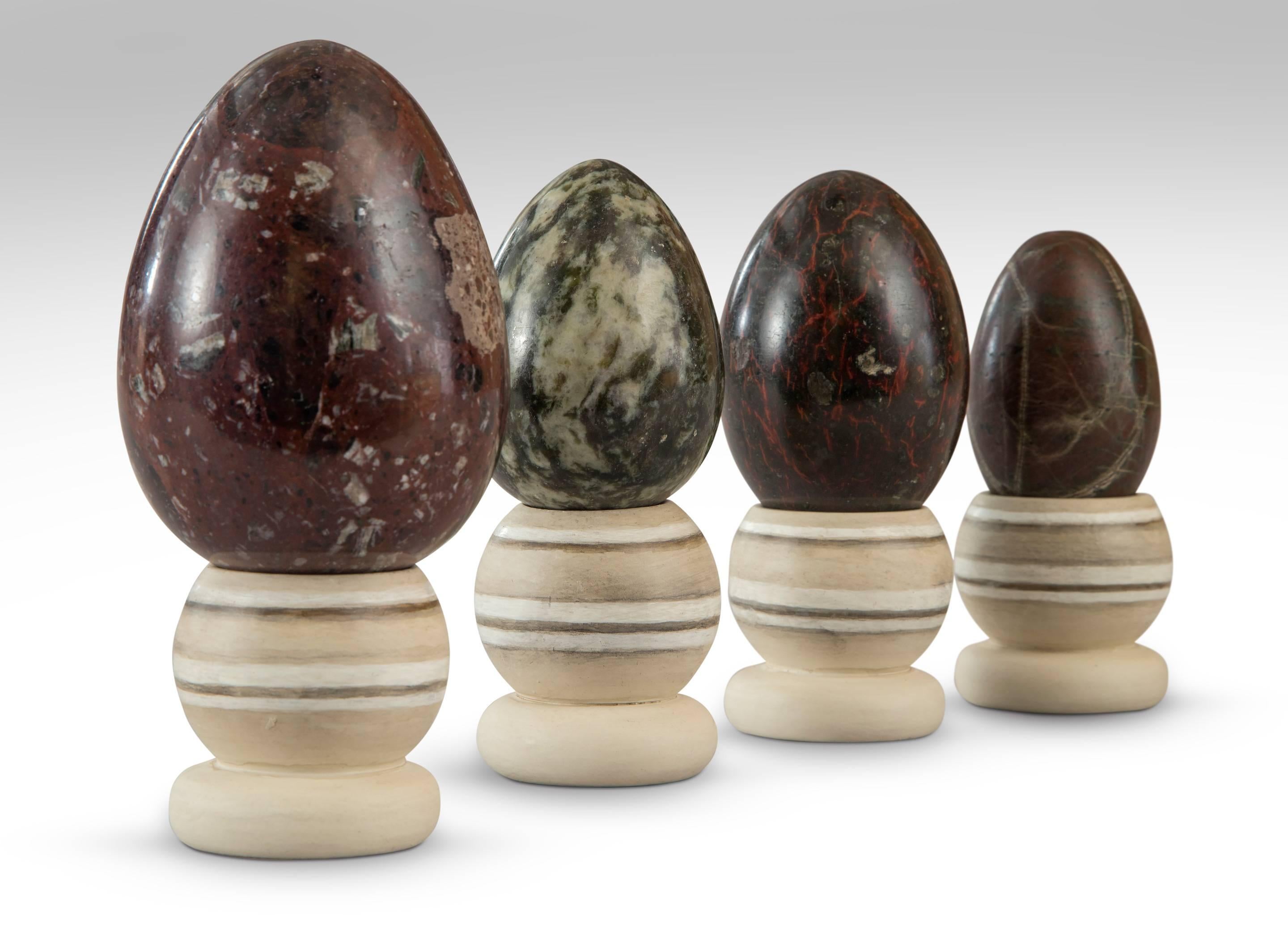 A set of four egg-shaped specimen marbles
An attractive set of variegated specimen marble eggs of graduated size on turned and painted wooden stands. Largest 5.75
