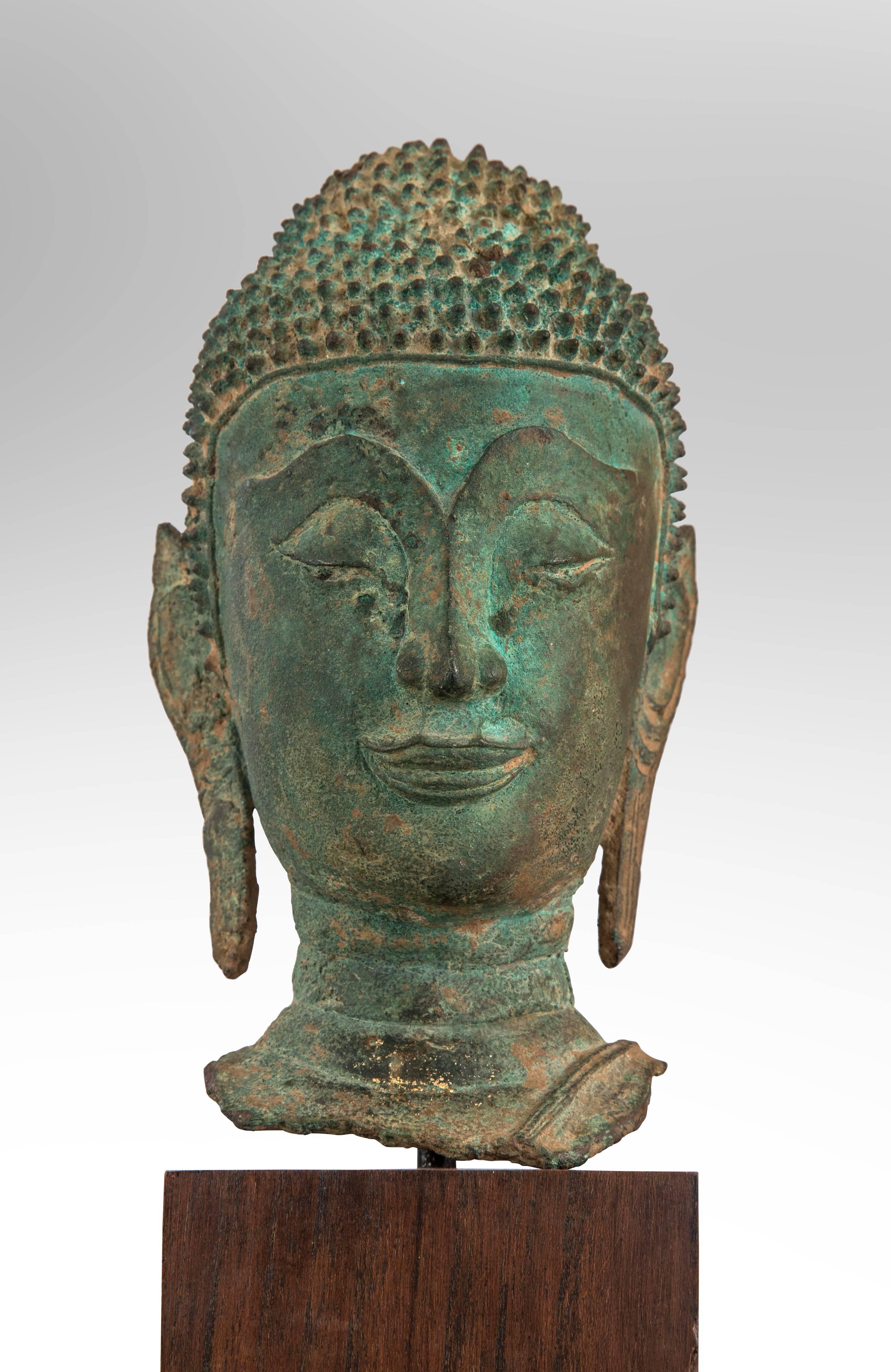 A Thai Verdigris bronze Buddha head
Late Ayutthaya style in verdigris patinated bronze, the bust on a later stand. Ketumala missing.
17th century or later.