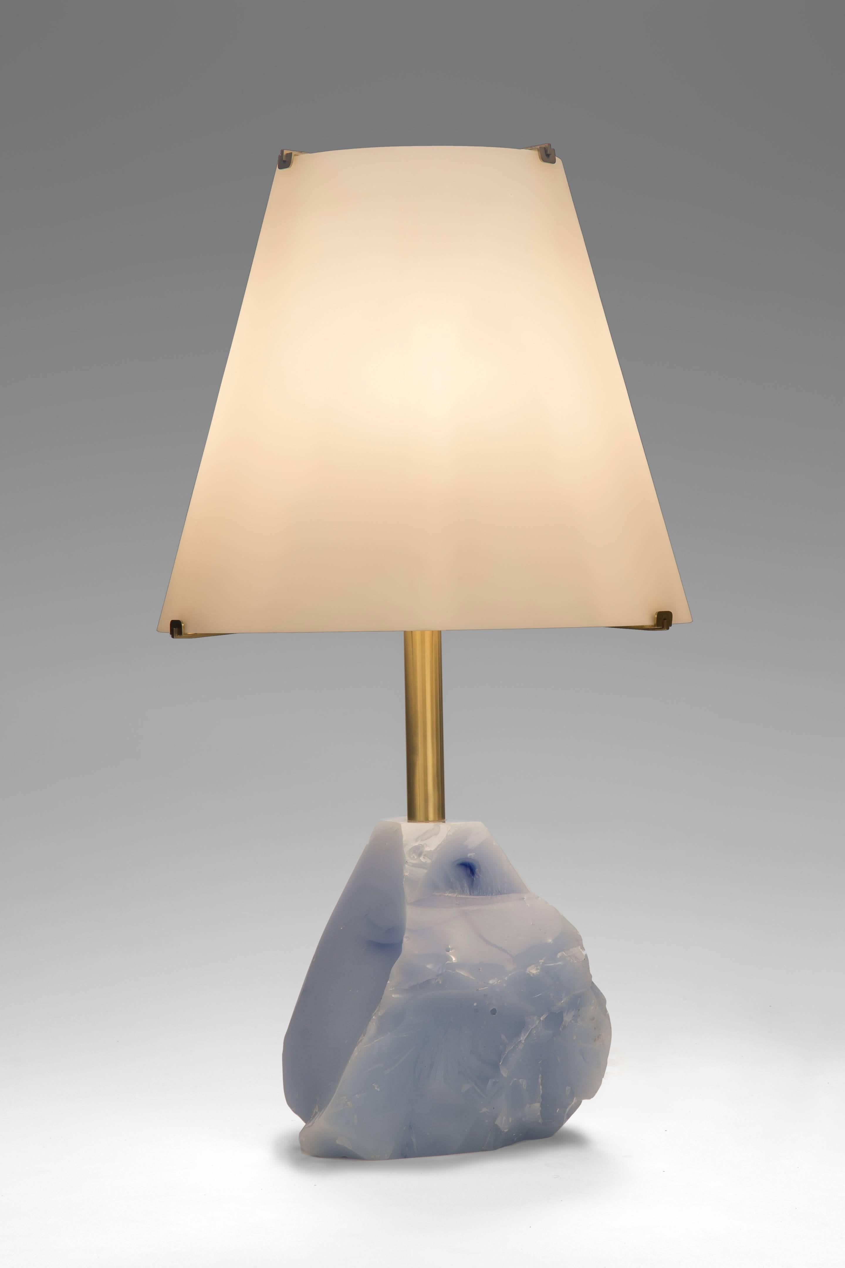 Each with an opaline glass shade mounted to a conical brass standard, above a carved vintage pale blue glass base. 