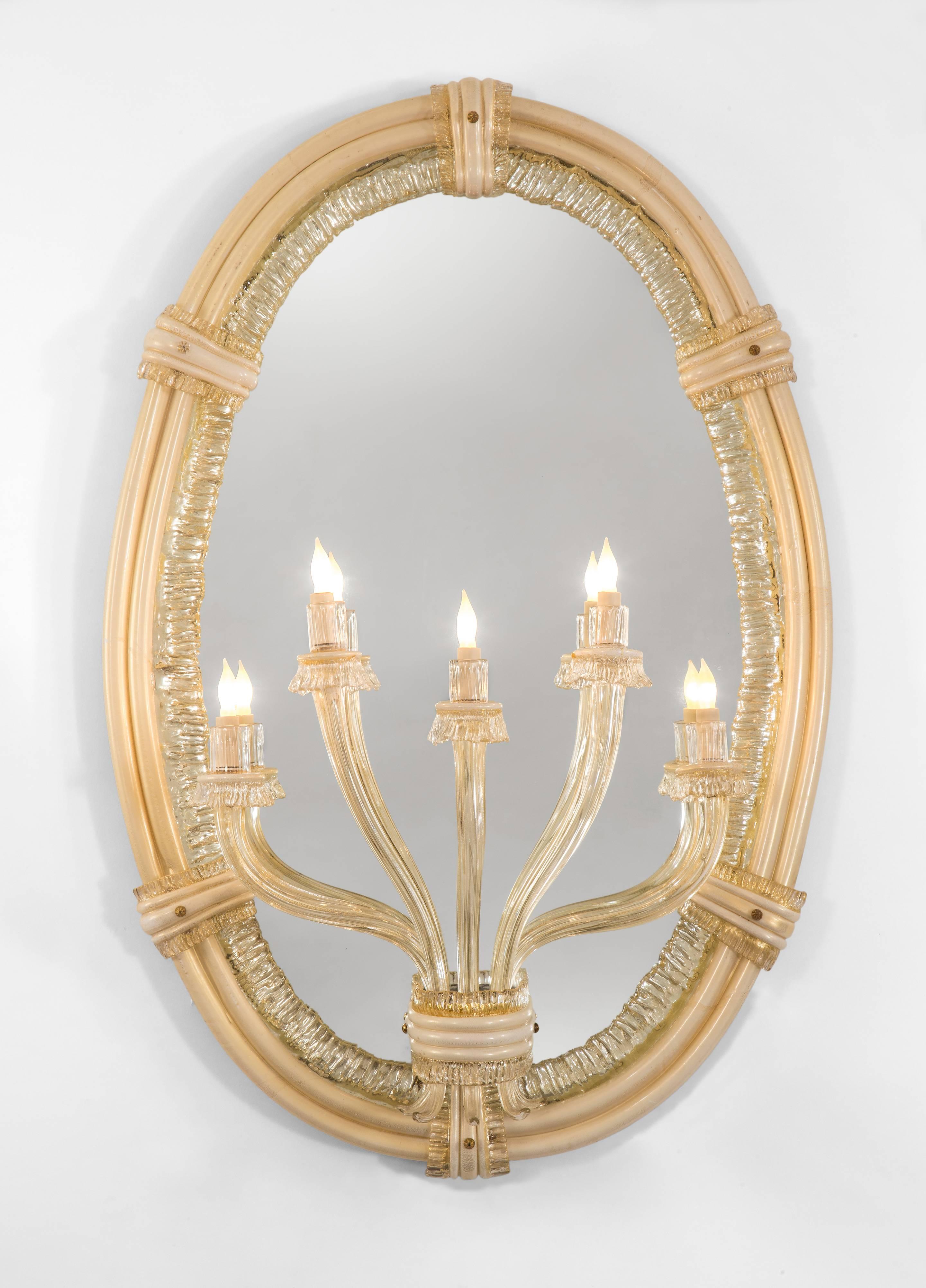 A magnificent composition of gorgeous handblown glass of a subtle cream and clear glass. With an impressive provenance. Each oval mirror plate within a lattimo and colorless ribbon glass frame, gold inclusions throughout, the oval frame fastened