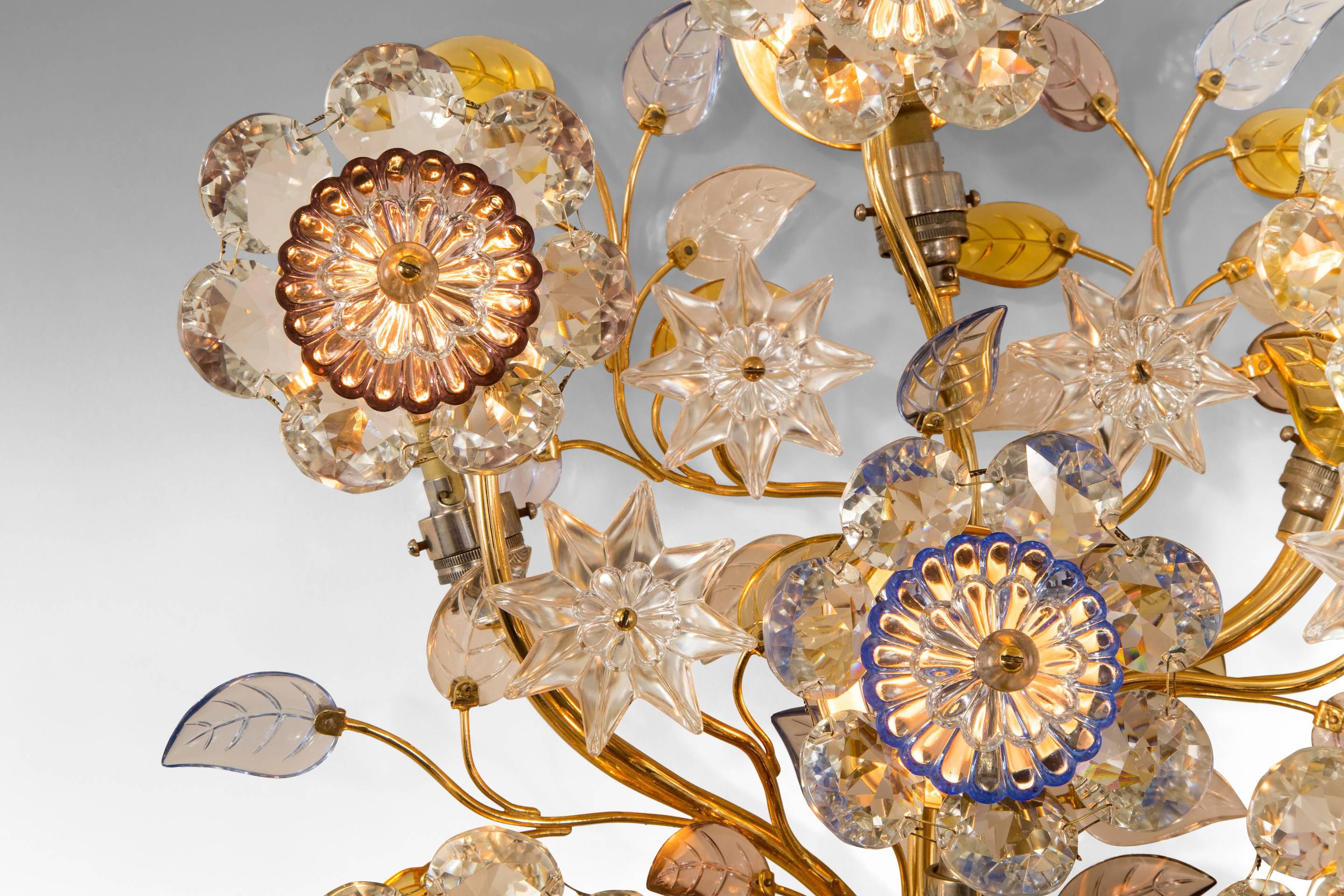 Each bouquet composed of serpentine branches supporting colored and colorless glass stars, leaves and flowers, with nine light holders, the branches bound with a bracelet of colorless beaded glass.

A related model is illustrated by Gerhard Krohn