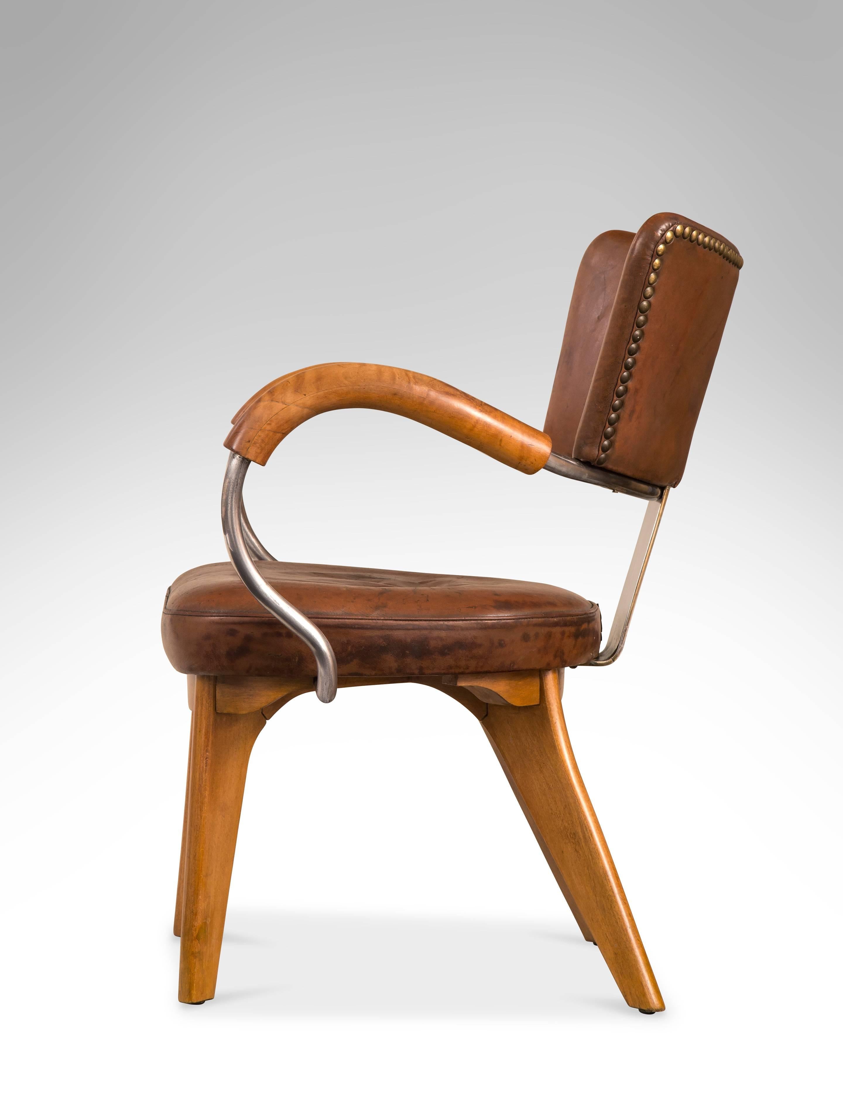 This bold early modern chair was undoubtedly a prototype, still retaining its original leather. The chair is incredibly comfortable. The concave backrest, issuing two gracefully curved arms, above a padded leather cushion, on shaped legs. 

Sketches