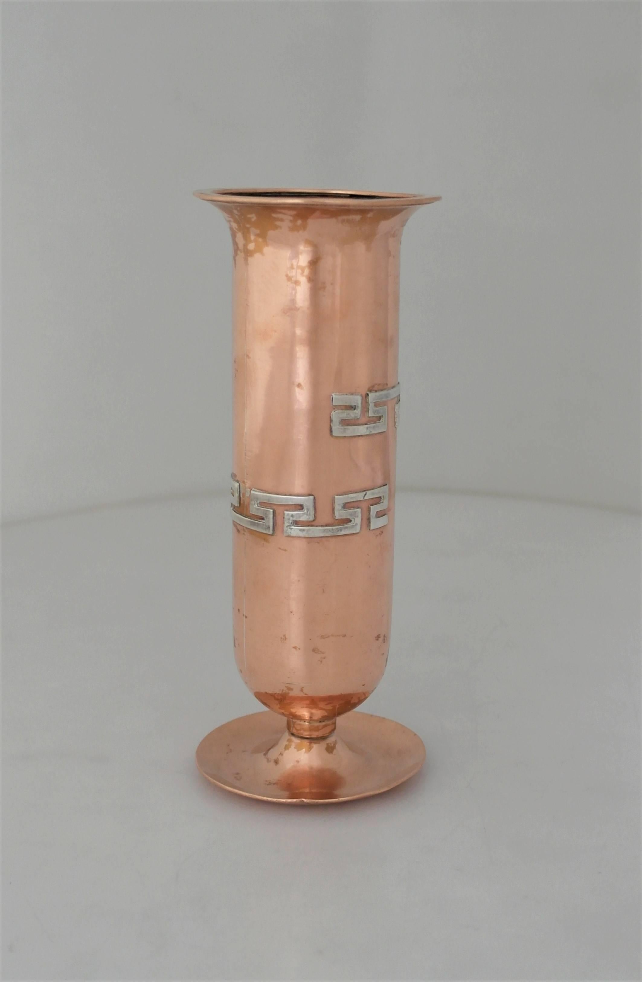 Being offered is a circa 1960 vase by renowned silversmith Victoria of Taxco, Mexico. Hand-wrought vase made of copper with an applied silver Pre-Columbian motif decoration, all resting on a circular raised base. Dimensions: 7 1/4" height x
