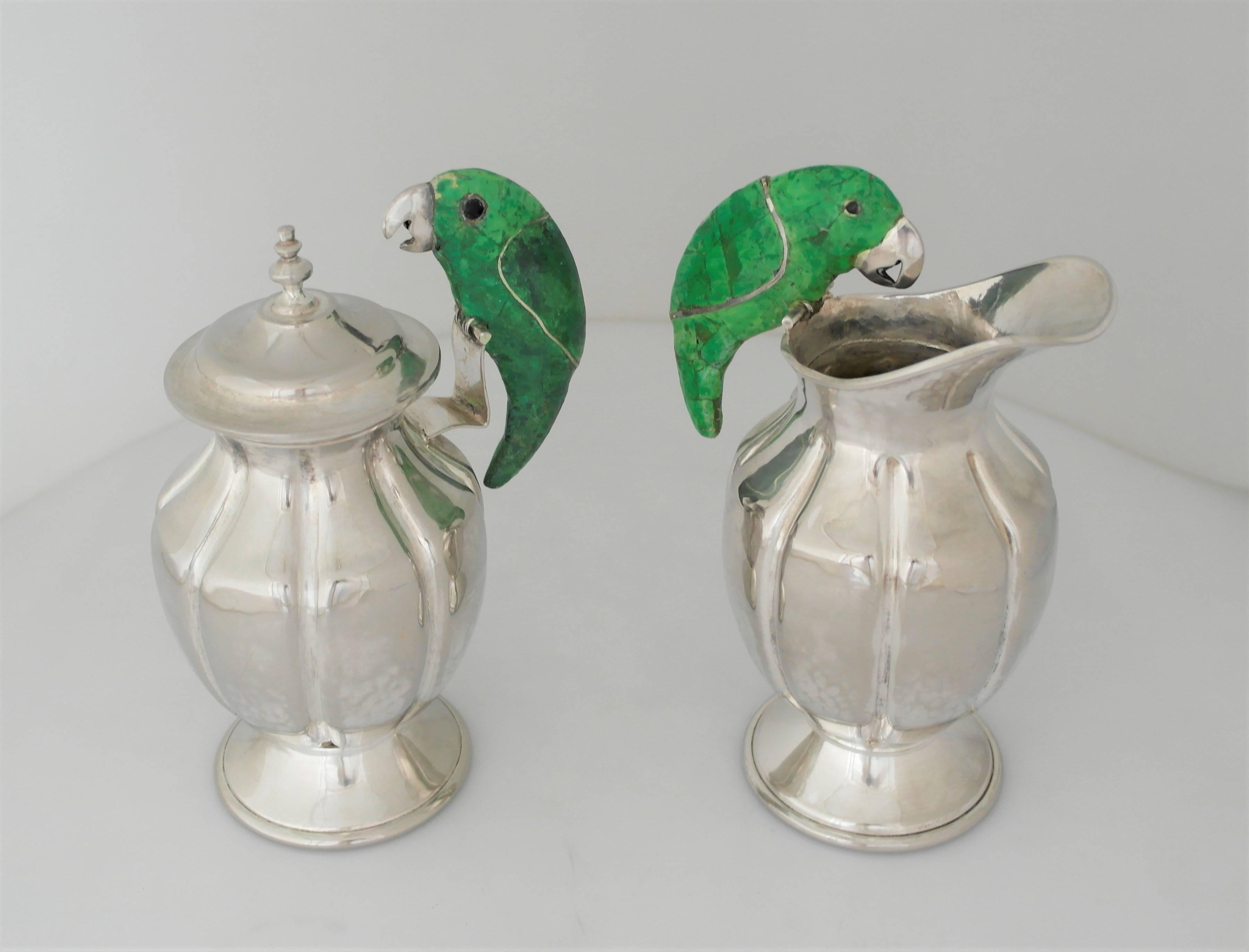 Being offered is a large silver plate sugar and creamer made in Mexico. Hand-wrought pair, lobed, with malachite inlay parrot handles; resting on raised circular bases. Dimensions: 8
