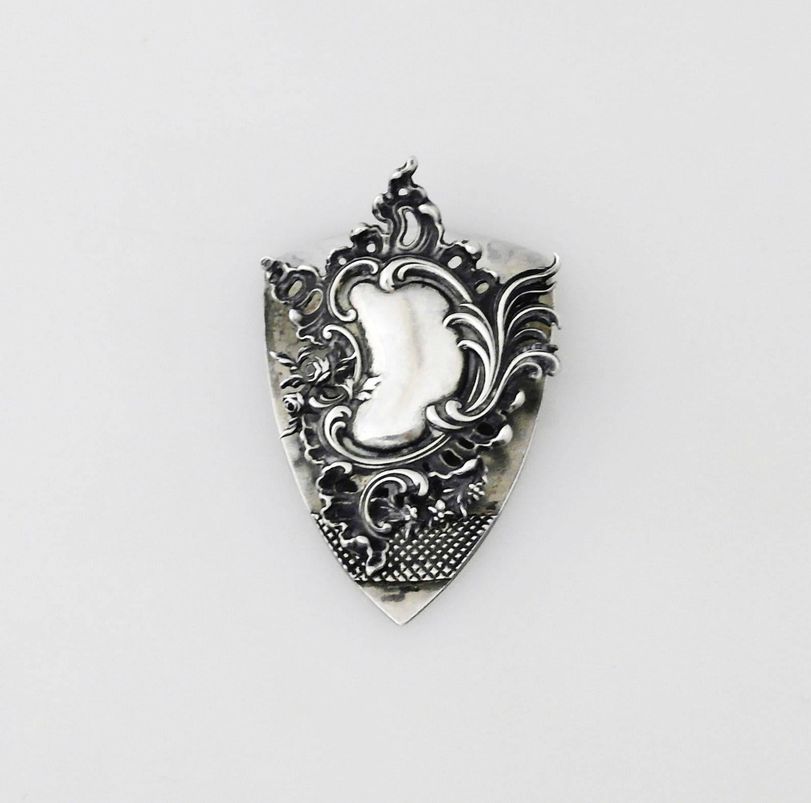 Being offered is a fine sterling silver document clip by George Shiebler of New York; crest shaped with floral and multiple scroll motifs on the clip; superb detail. Dimensions: 2 1/2