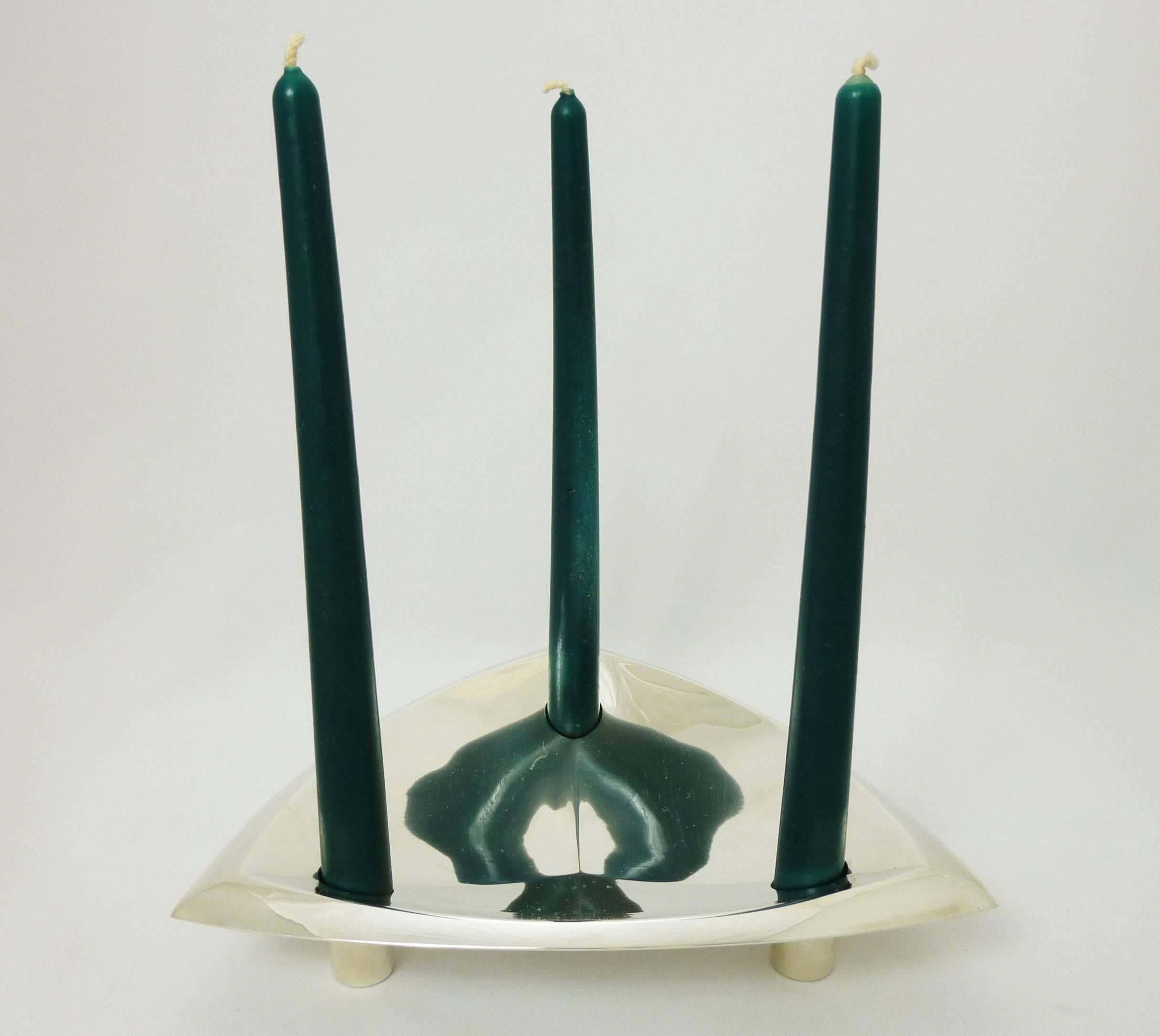 Being offered is a circa 1952 sterling silver candleholder by Tiffany & Co. of New York. Of modernist form, executed in a triangular design, made to hold three tapered candlesticks; resting on three feet. Dimensions: 9 inches diameter. Marked as