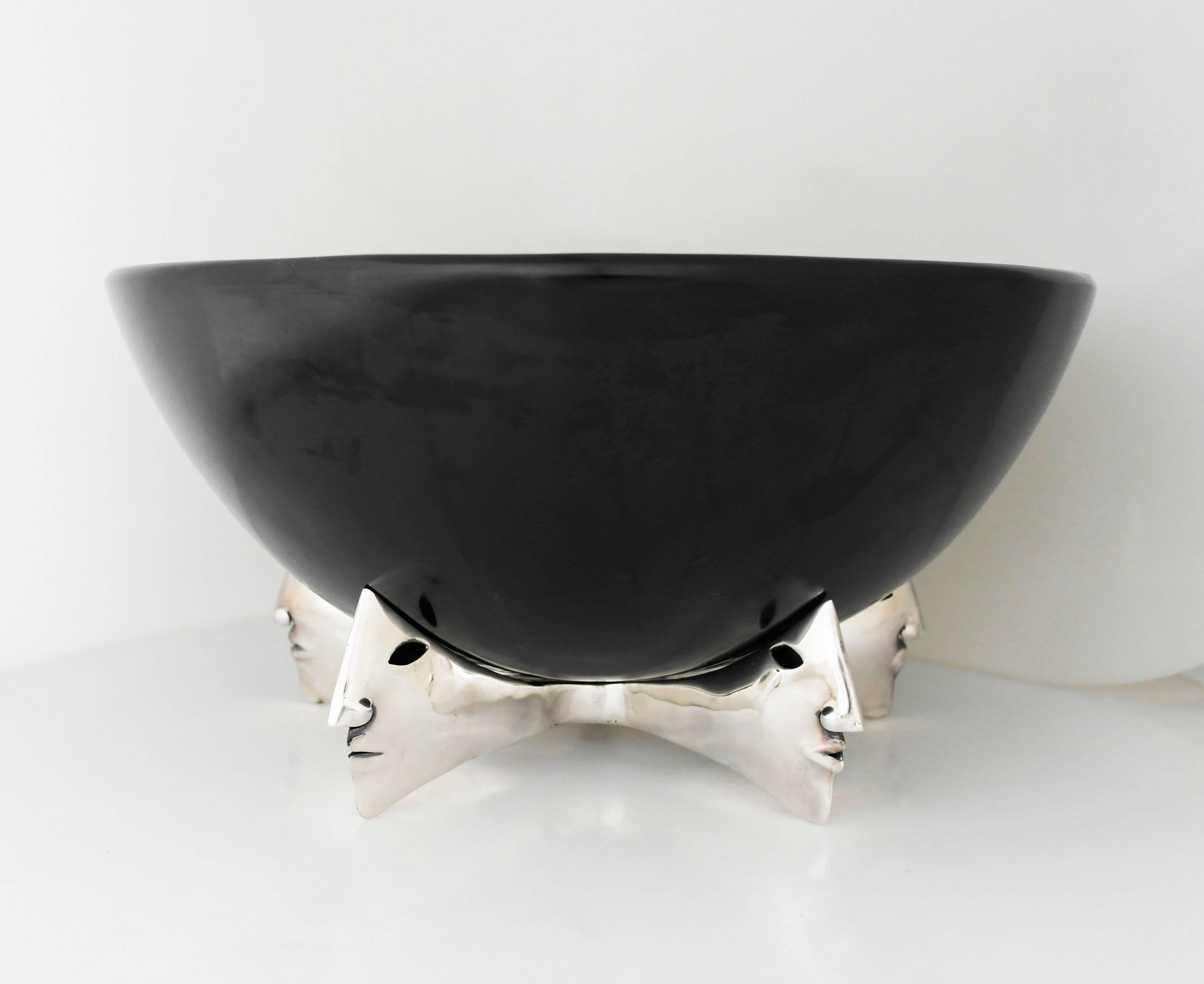 Being offered is a large and stupendous centerpiece bowl by Emilia Castillo of Taxco, Mexico. Comprising a stone carved bowl of simple form, resting on a sterling silver modernist stand revealing five profiles of Pre-Columbian influence. Dimensions: