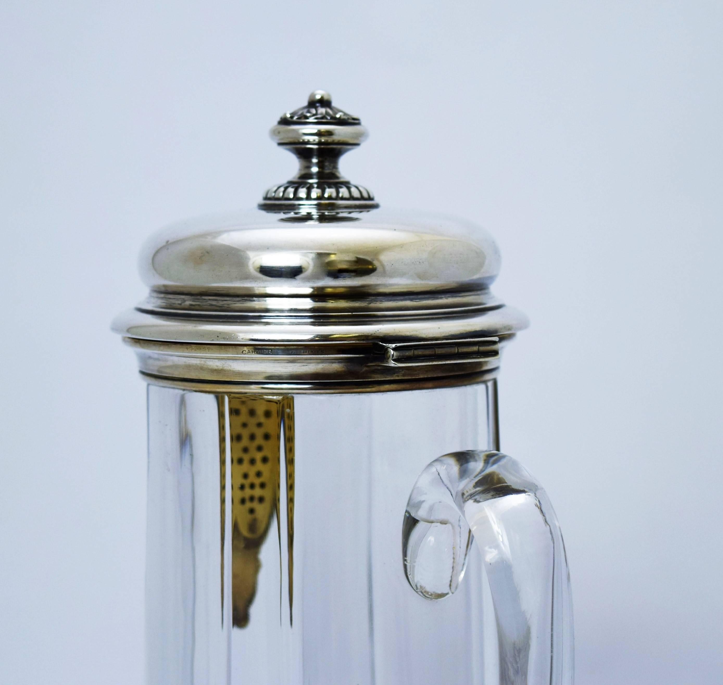 Offering a circa 1935 sterling silver and mounted glass claret jug by Cartier of France. Dimensions: 11 1/2 inches height. Marked as illustrated. In excellent condition.