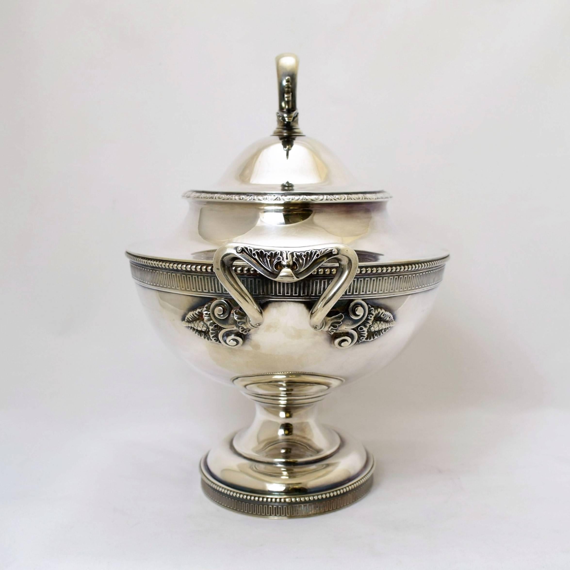Being offered is a circa 1875 sterling silver tureen by Tiffany & Co. of New York. Large serving piece in the neoclassical style, adorned with egg and dart motifs on the body and pedestal base. Dimensions: 16.5 inches from handle to handle, 13
