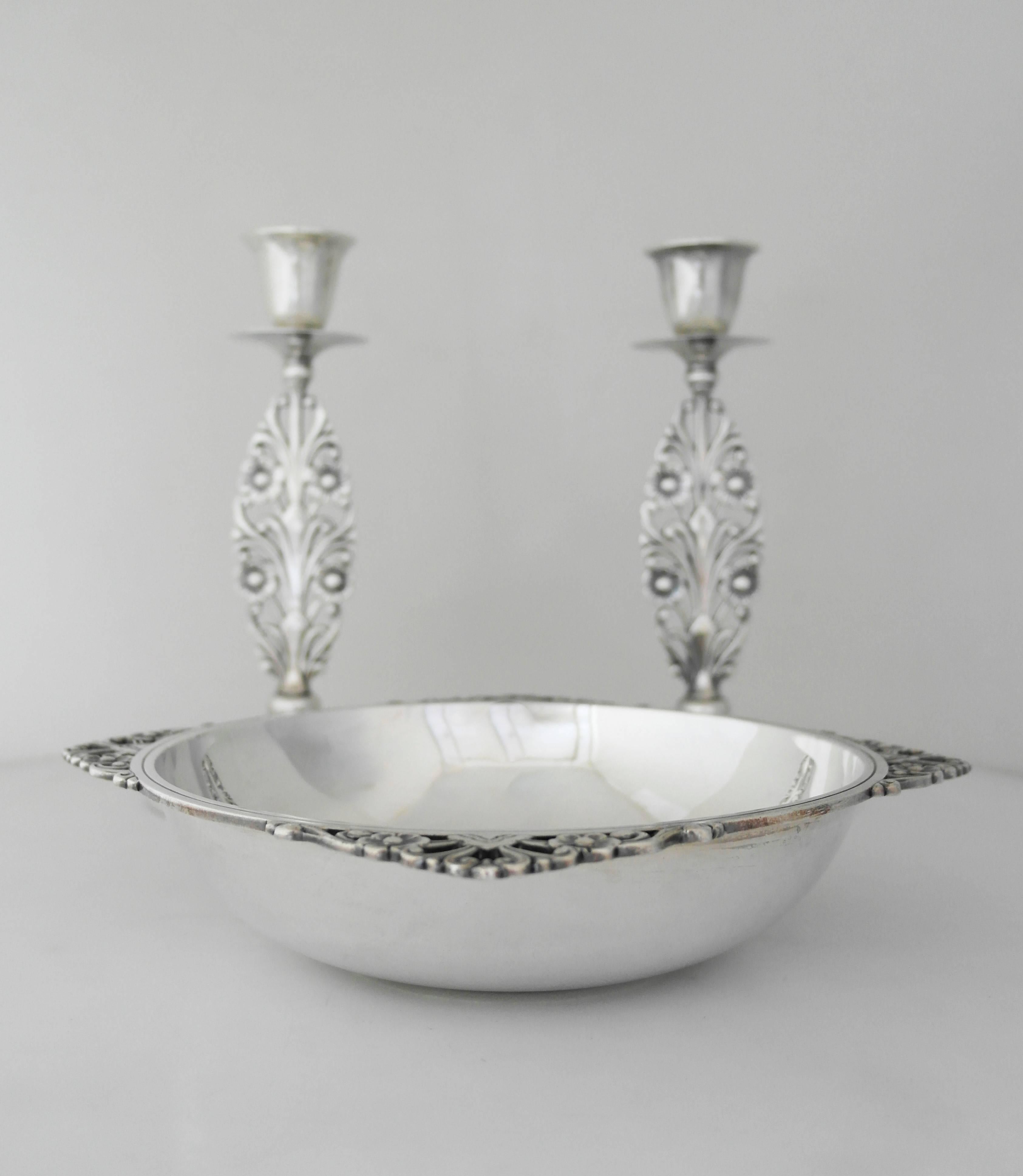 Being offered are a pair of Art Deco candlesticks and matching bowl by Tiffany & Co. of New York, circa 1925. Set decorated with pierced floral and scroll motifs on the stems of the candlesticks, as well as the bowl. Dimensions: bowl- 10 inches