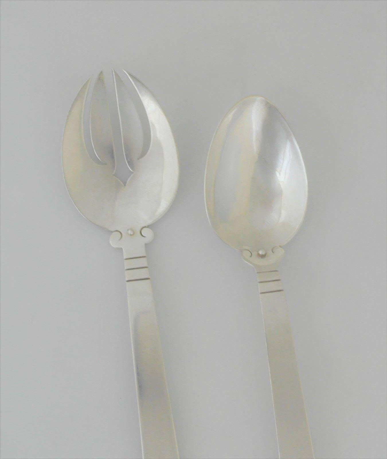 Being offered are a pair of sterling silver salad servers by Hector Aguilar of Taxco, Mexico. In the Aztec pattern. Dimensions: 10 1/4". Marked as illustrated. In excellent condition with normal wear from age and use.