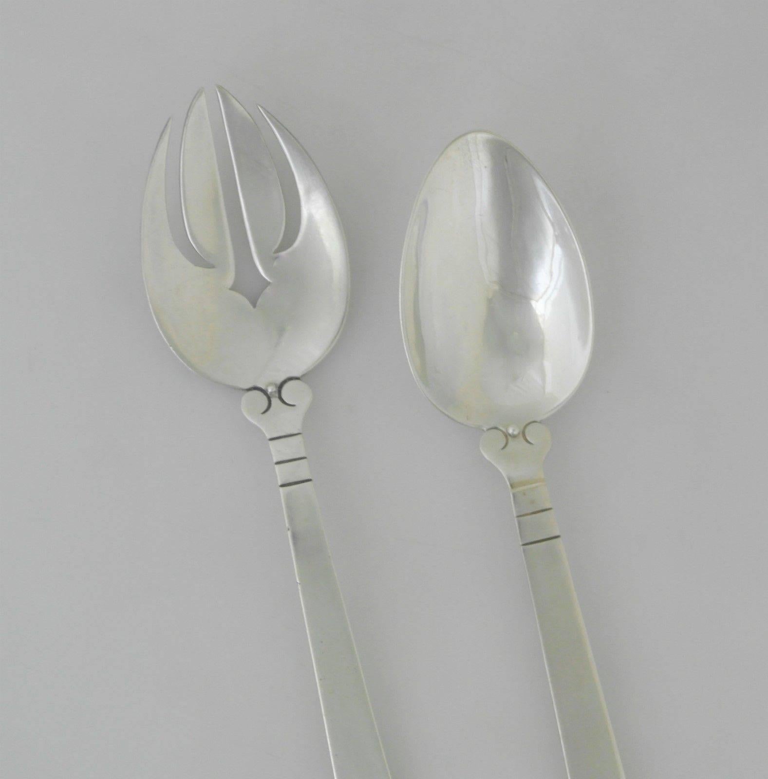 Being offered are a pair of sterling silver salad servers by Hector Aguilar of Taxco, Mexico. In the Aztec pattern. Dimensions: 8 3/4". Marked as illustrated. In excellent condition with normal wear from age and use.