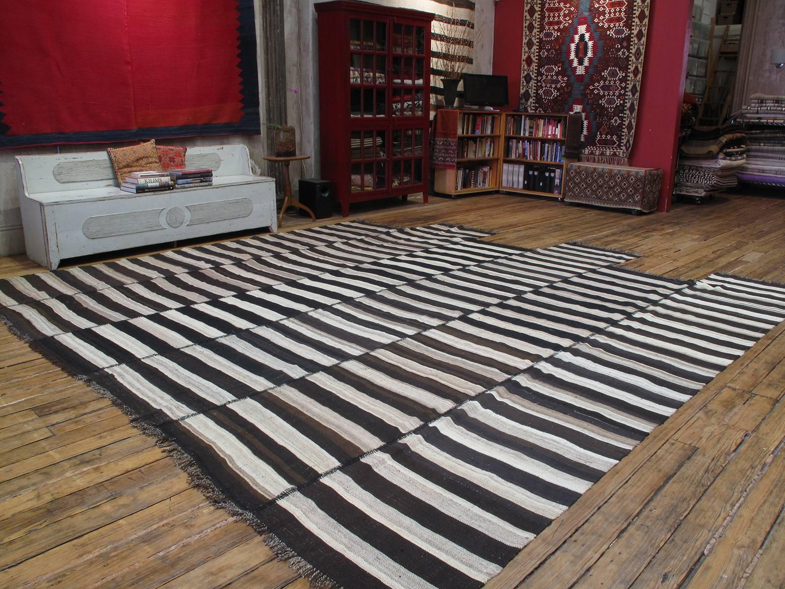 A simple everyday floor cover with great modern or contemporary appeal.
This large tribal Kilim from Northern Iran with alternating bands of black-brown 
and ivory, actually consists two Kilims, each with three panels, that were joined.

(The