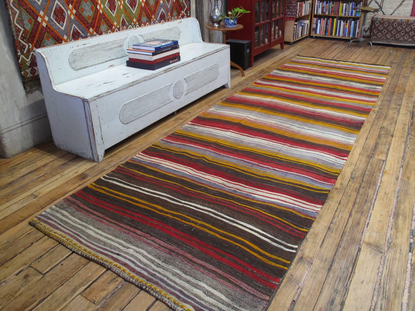 Banded Kilim, wide runner rug. A beautiful old tribal flat-weave runner rug from West-Central Turkey, woven in characteristic wide runner format, with alternating bands of color. An older example with great patina and pleasing irregularities in its