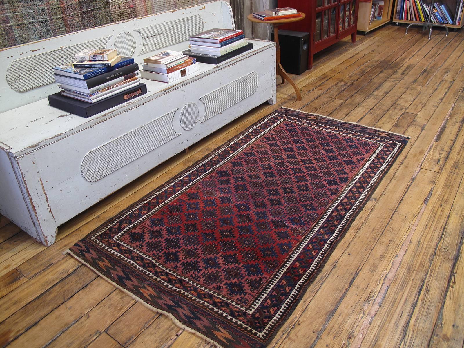 Antique Baluch rug. An antique tribal rug from the Iran-Afghan border area, attributed to groups generally defined as Baluch. Deep saturated colors, highly stylized geometric designs are hallmarks of this region's weaving traditions. A simple design