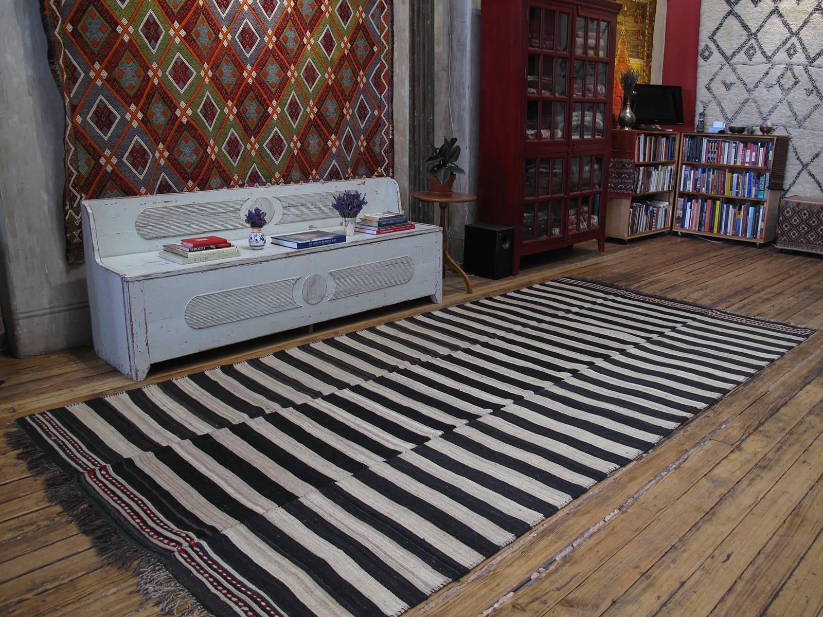 An old tribal flat-weave from Northern Iran, woven in three narrow panels, with alternating bands of ivory and dark brown or black, to be used as a simple everyday floor cover in the weaver's household. A strikingly modern look, with great texture