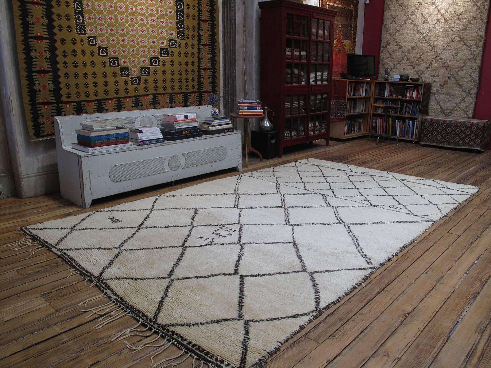 A superb old Moroccan Berber carpet of rare, large proportions, by the Beni Ouarain tribes. The classical diamond grid theme is executed with great dynamism, featuring many interruptions and whimsical details. The weave is dense, the wool quality is