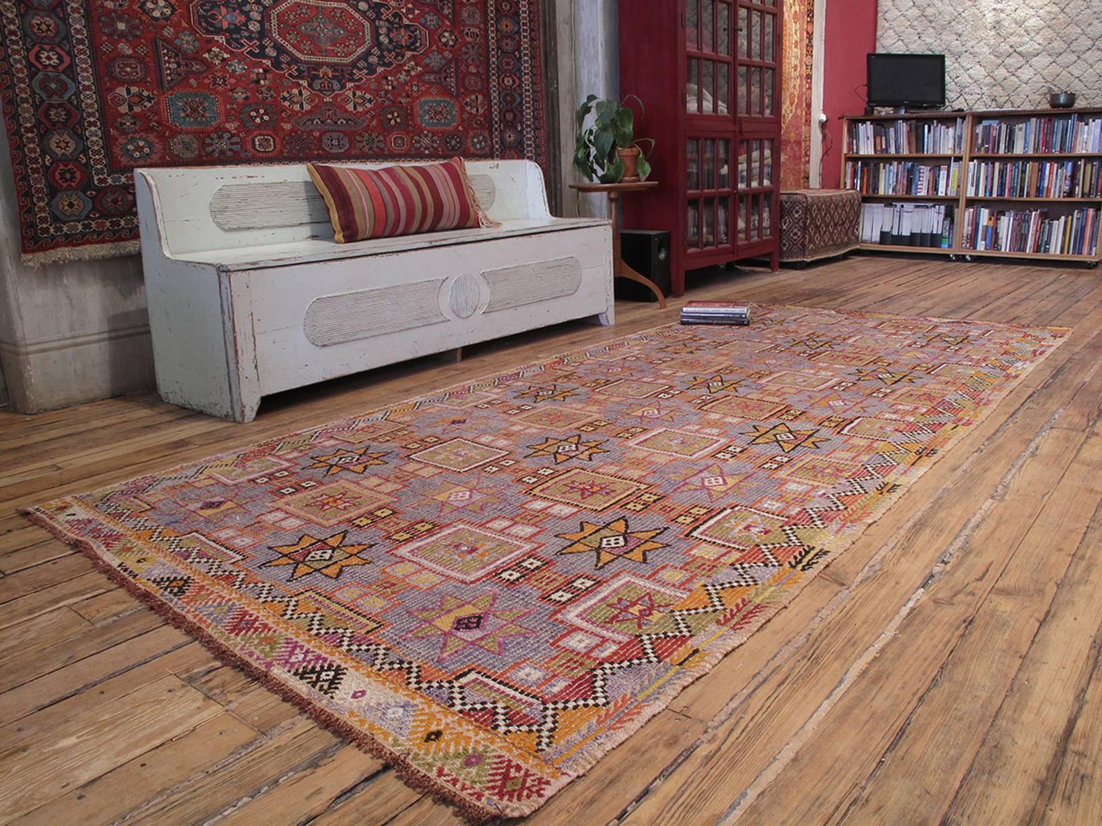 A lovely old tribal floor cover from Western Turkey, woven in an intricate brocading technique, with a simple design of stars in soft colors. The wide runner format is unusual for this type.