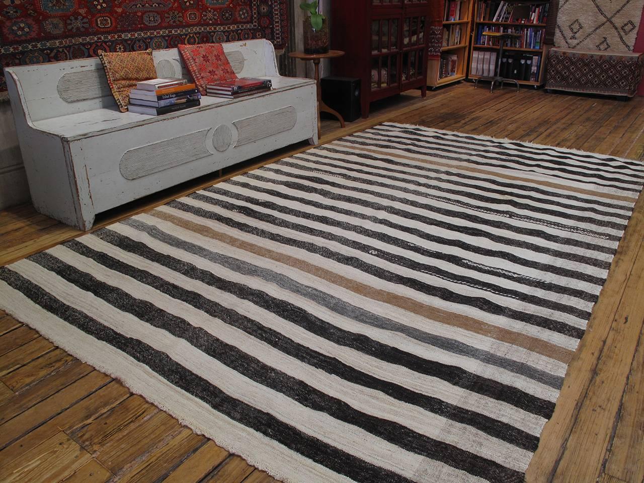 A beautiful, simple flat-weave from West-Central Turkey, woven with wool in alternating bands of natural ivory, beige, gray and brown. Scattered tribal motifs in brocading add to the charm. Unusually large for the type.