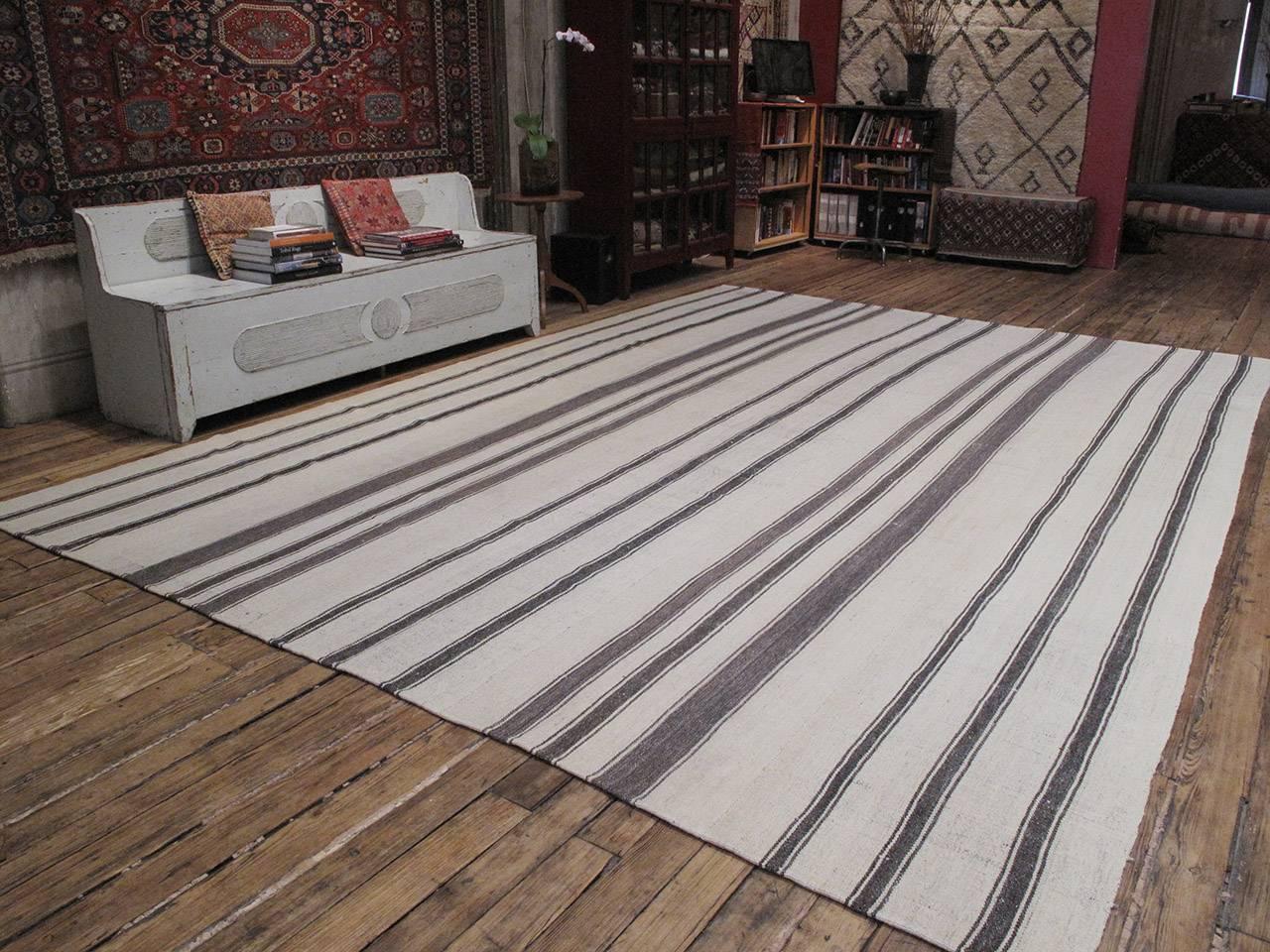 An old tribal flat-weave of large proportions from Central Turkey, woven entirely with wool in natural tones of ivory and dark brown/gray in alternating stripes. The wool quality is superb and the weave is very tight and heavy, creating a very