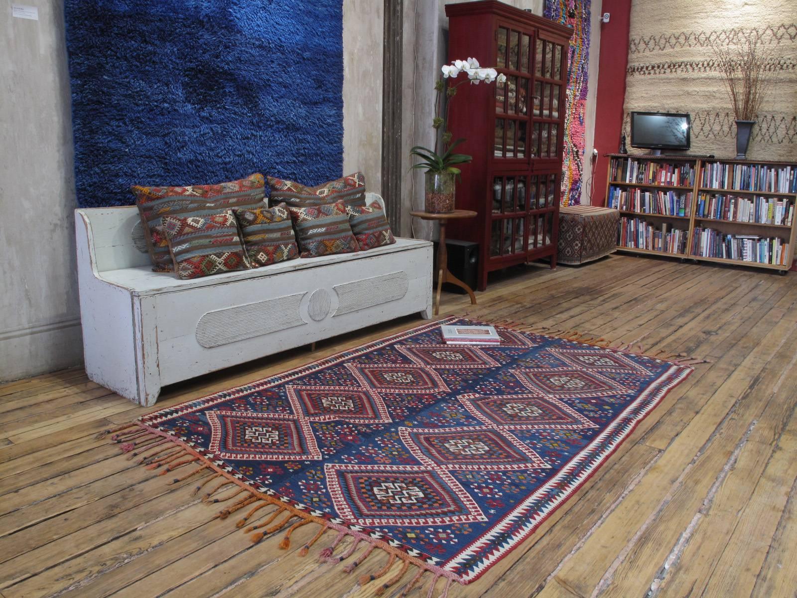 Un magnifique tissage plat tribal ancien de l'est de la Turquie, attribué aux tisserands kurdes de la région du lac de Van. Une interprétation très dynamique et joyeuse du design classique de ce groupe sur un fond bleu brillant. Tissés sur de petits