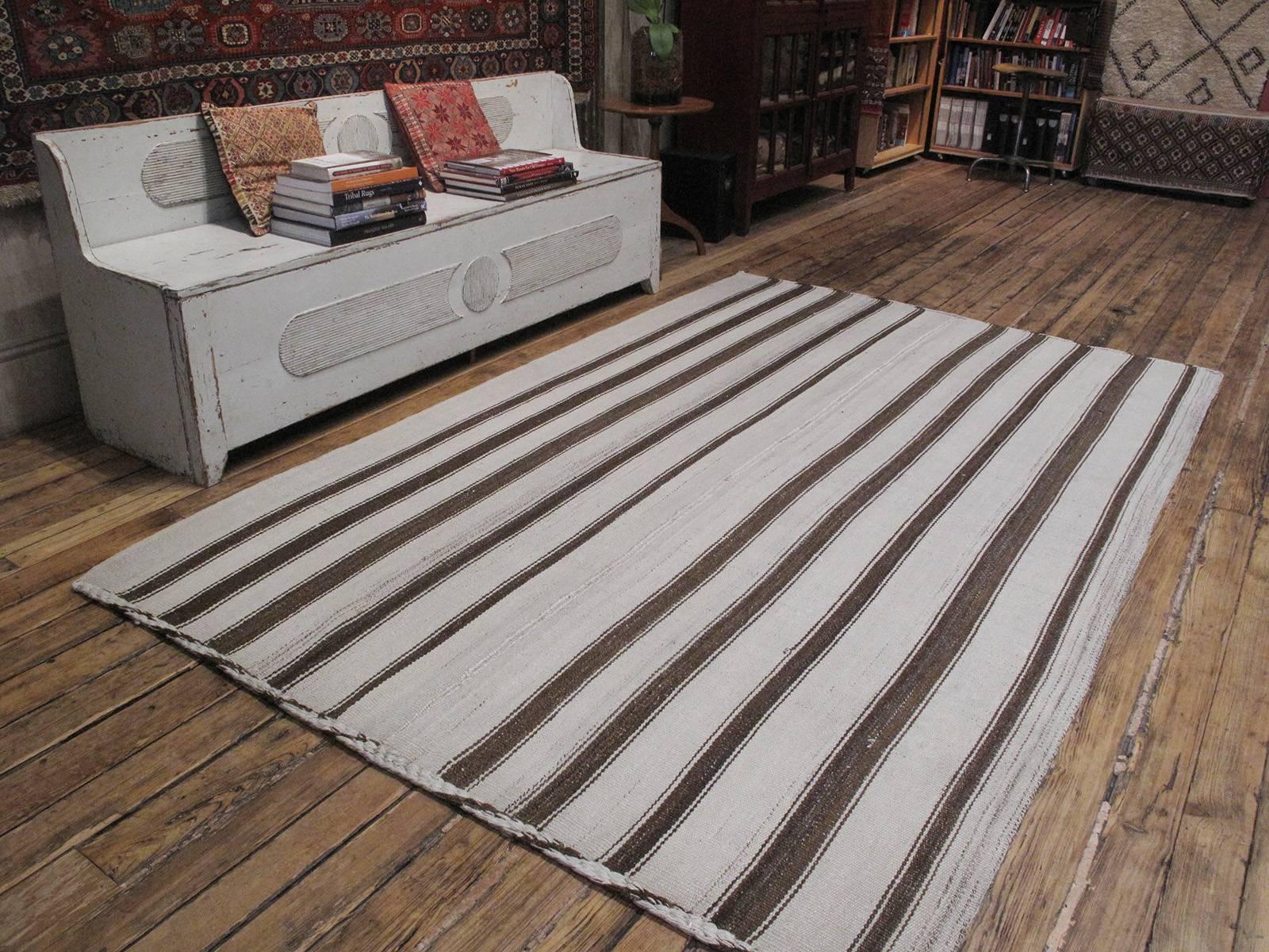 A simple old tribal flat-weave from Central Turkey, woven entirely with wool in natural tones of ivory and brown in alternating stripes. Its authentic simplicity makes it infinitely more appealing than its modern imitators.