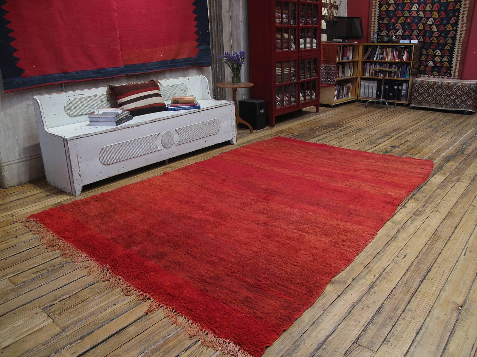 Red Beni Mguild Moroccan Berber rug. An old Moroccan Berber rug from the Middle Atlas mountains, attributed to the Beni Mguild tribes. Monochromatic rugs, with variations in color intensity and with minimal or no motifs, are typical for this tribe