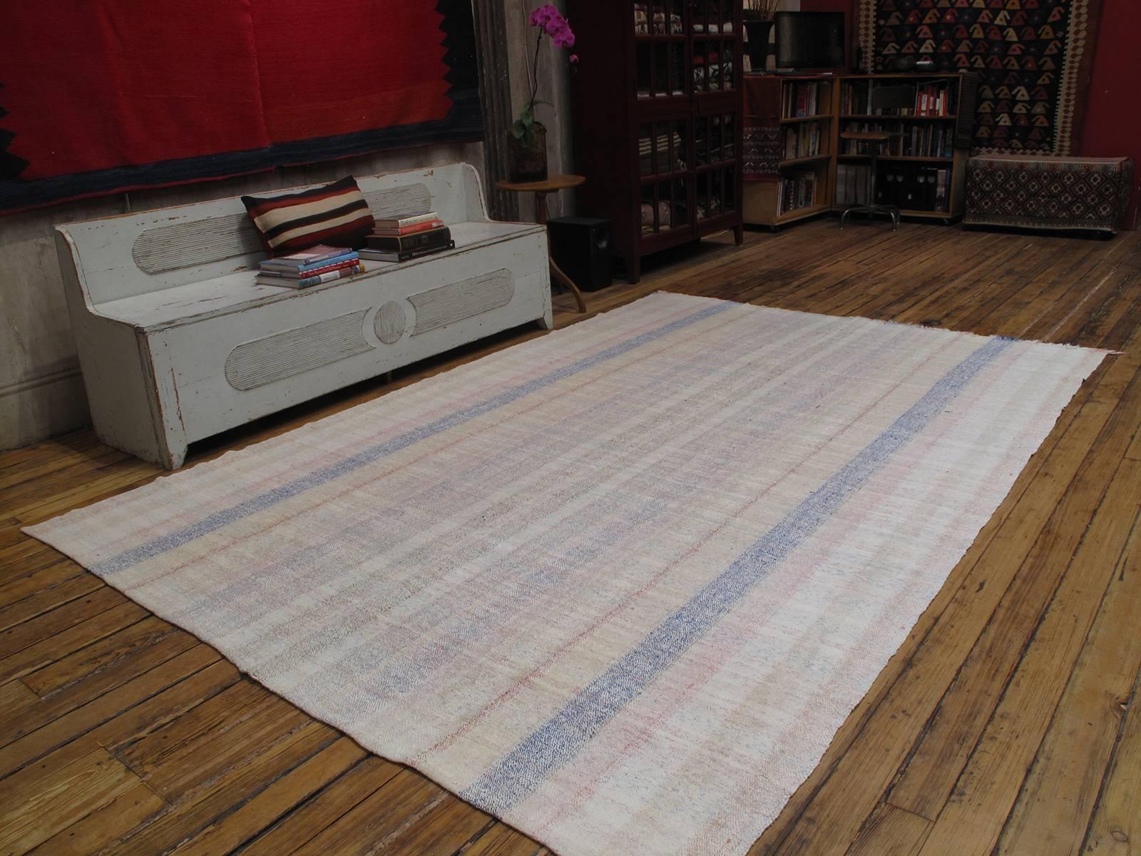 A simple old floor cover from Turkey, woven with an interesting mixture of cotton yarn and colorful cotton rag. Unusually light color palette and large useful size.