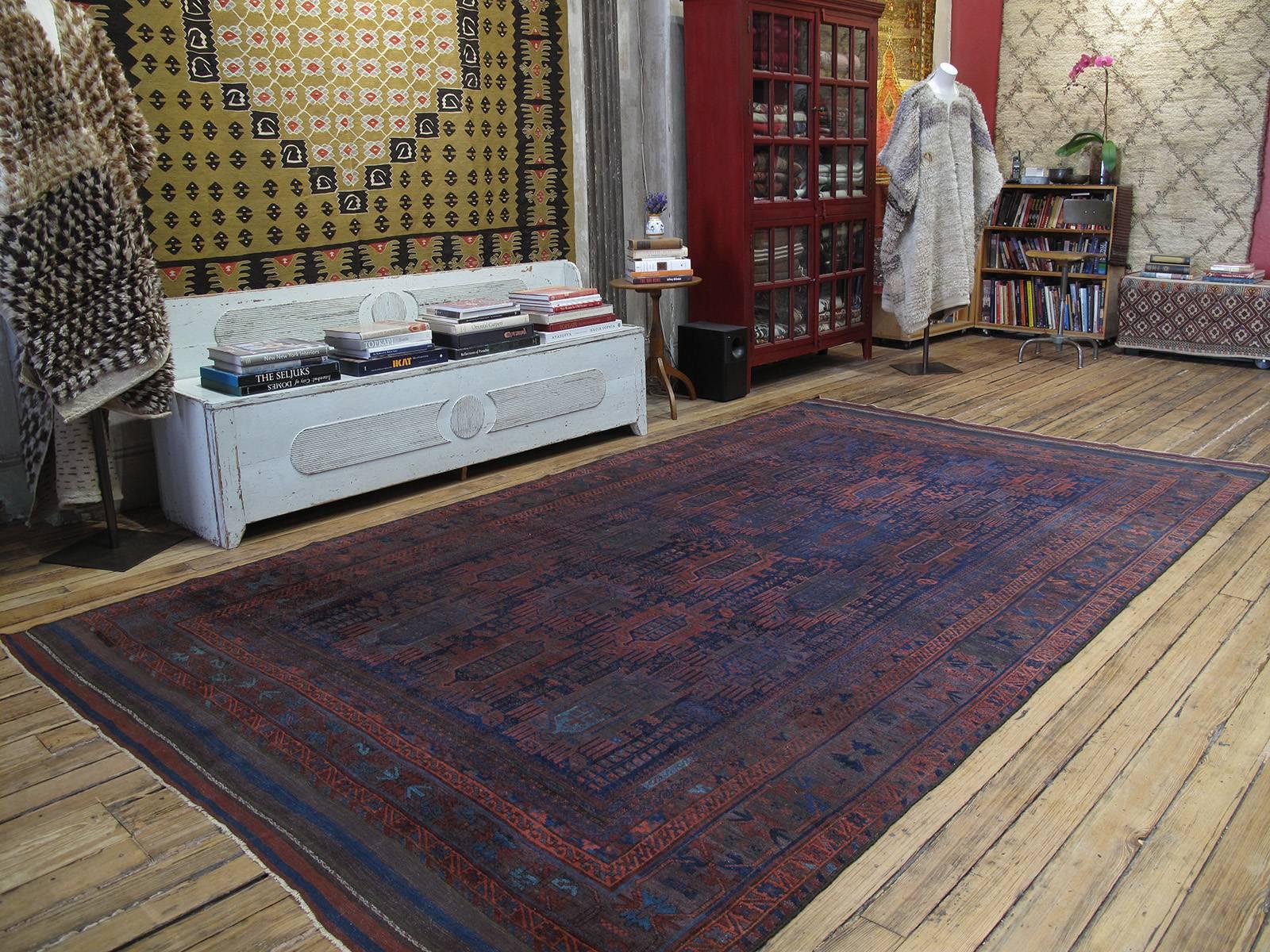 Tall, dark and handsome! A large tribal carpet from the border regions between Iran and Afghanistan, attributed to one of the groups generally referred to as Baluch. Displaying a vibrant tribal sensibility, with many whimsical details, carpets like