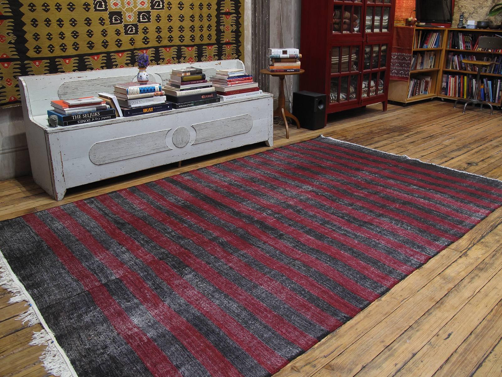 Banded goat hair Kilim rug. A primitive, dramatic tribal flat-weave rug woven entirely with goat hair in natural dark brown (almost black) and red bands. Woven as a utilitarian floor cover or rug, it has a rough texture. Rug has great