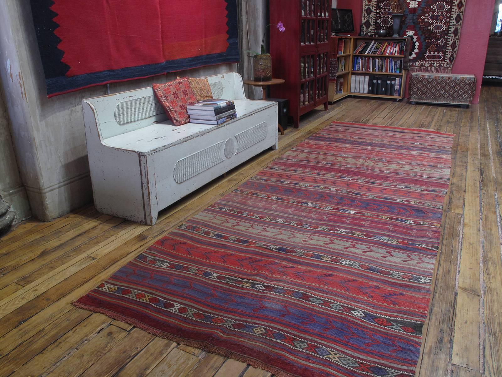 An old kilim (flat-weave) from Central Turkey, woven in the characteristic wide runner format, with alternating bands of color and brocaded motifs throughout. Can be shortened, if necessary.