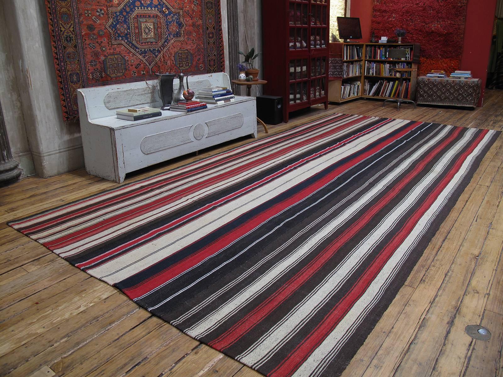 Large Kilim rug with vertical stripes. A large tribal floor cover or rug, woven with goat hair and wool in natural tones and red stripes. Very high quality weaving in excellent condition. (Rug size can be adjusted. Please inquire.)