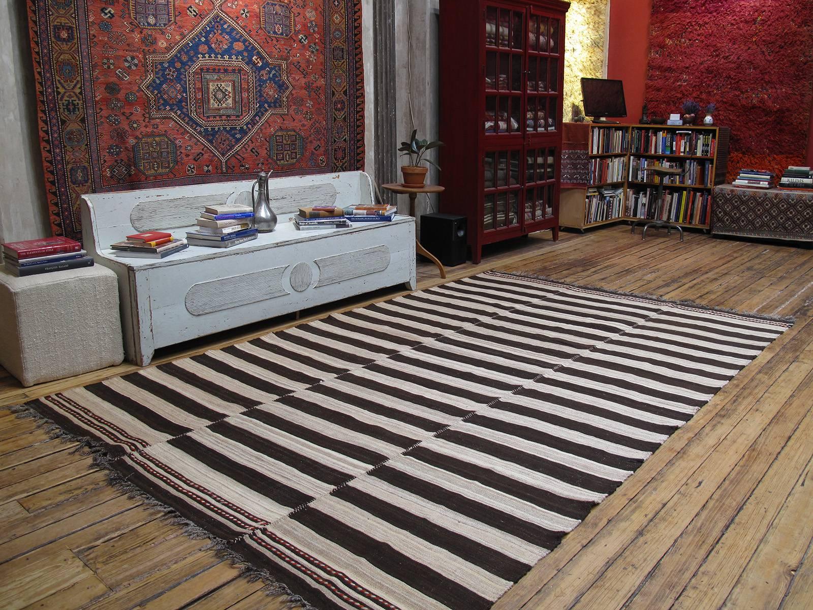 An old tribal floor cover from Northern Iran, woven in three narrow panels with alternating bands of ivory and dark brown. A strikingly modern look with great texture and patina that cannot be replicated in contemporary weavings.