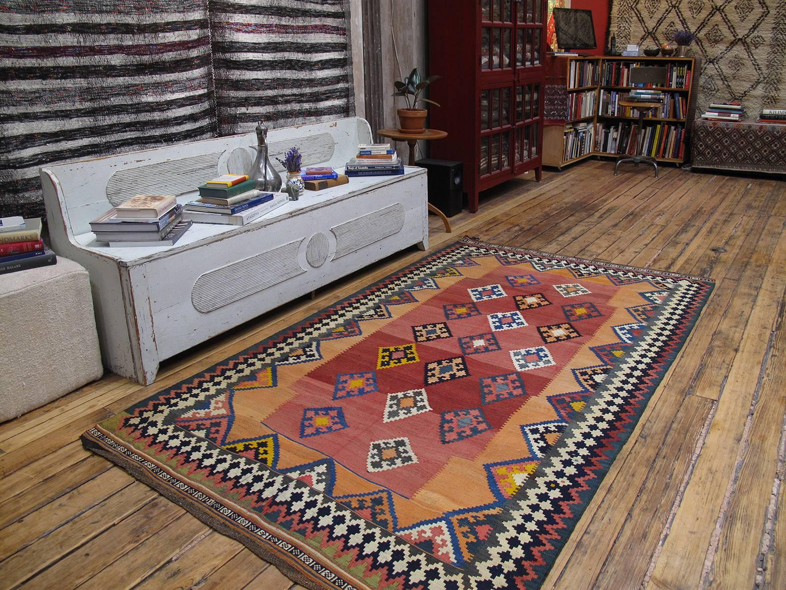 A lovely old tribal Kilim from Southwest Iran (Persia), by the Qashqai, a Turkic speaking confederation of tribes, who are very prolific weavers. Dating from the middle of 20th century, this Kilim still displays the fine work and design traditions