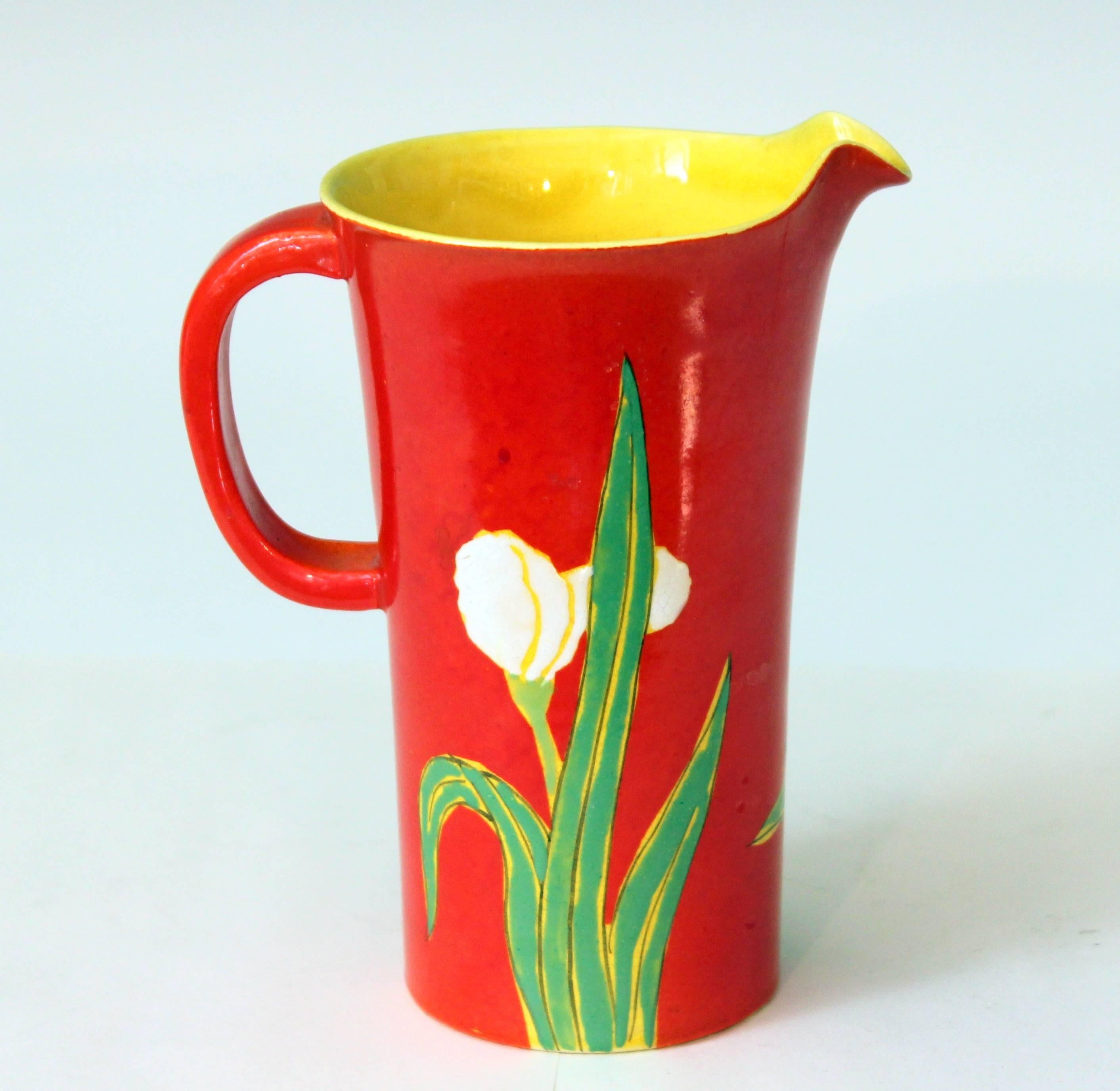 Vintage Awaji pottery iris pitcher decorated with irises in tactile enamels against an electric chrome red ground, circa 1920s. Incised potter's mark. Measures: 6